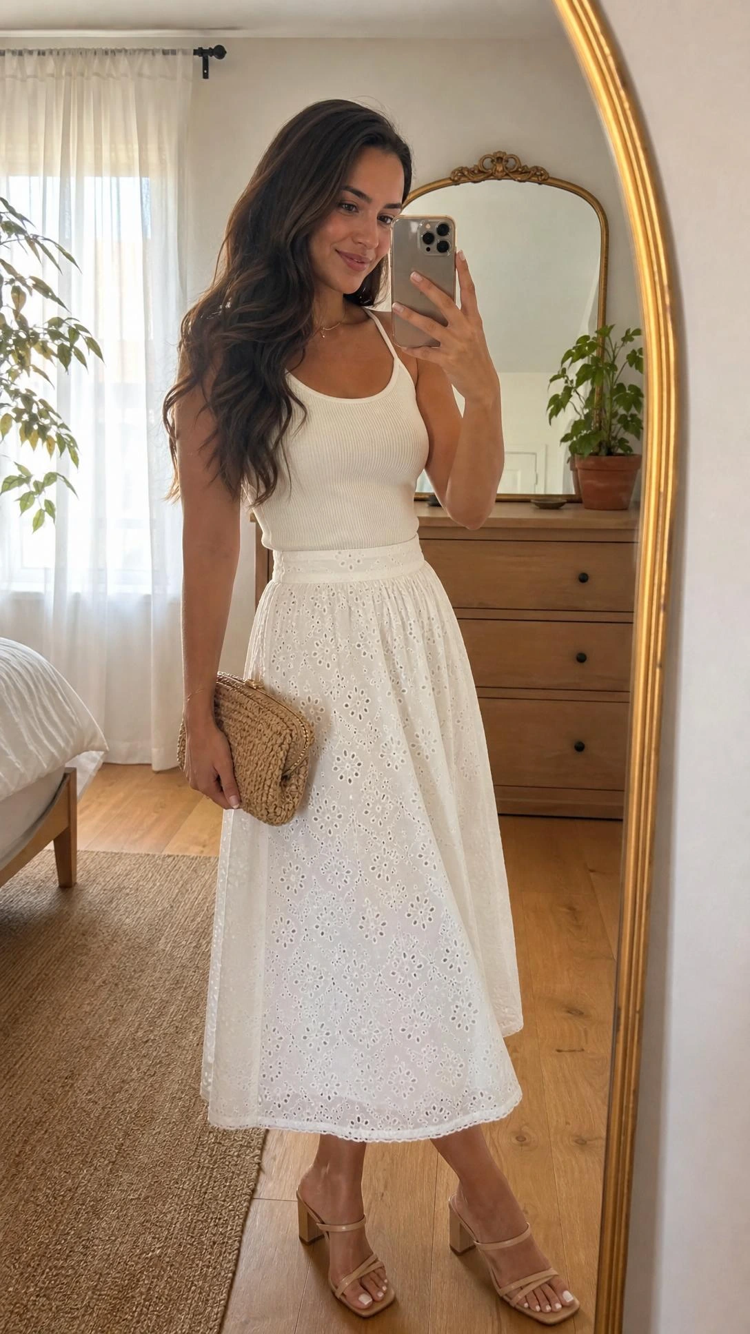 Young woman in white eyelet cotton midi skirt and fitted cream ribbed tank top, a chic summer graduation guest outfit captured in a sunlit bedroom mirror selfie