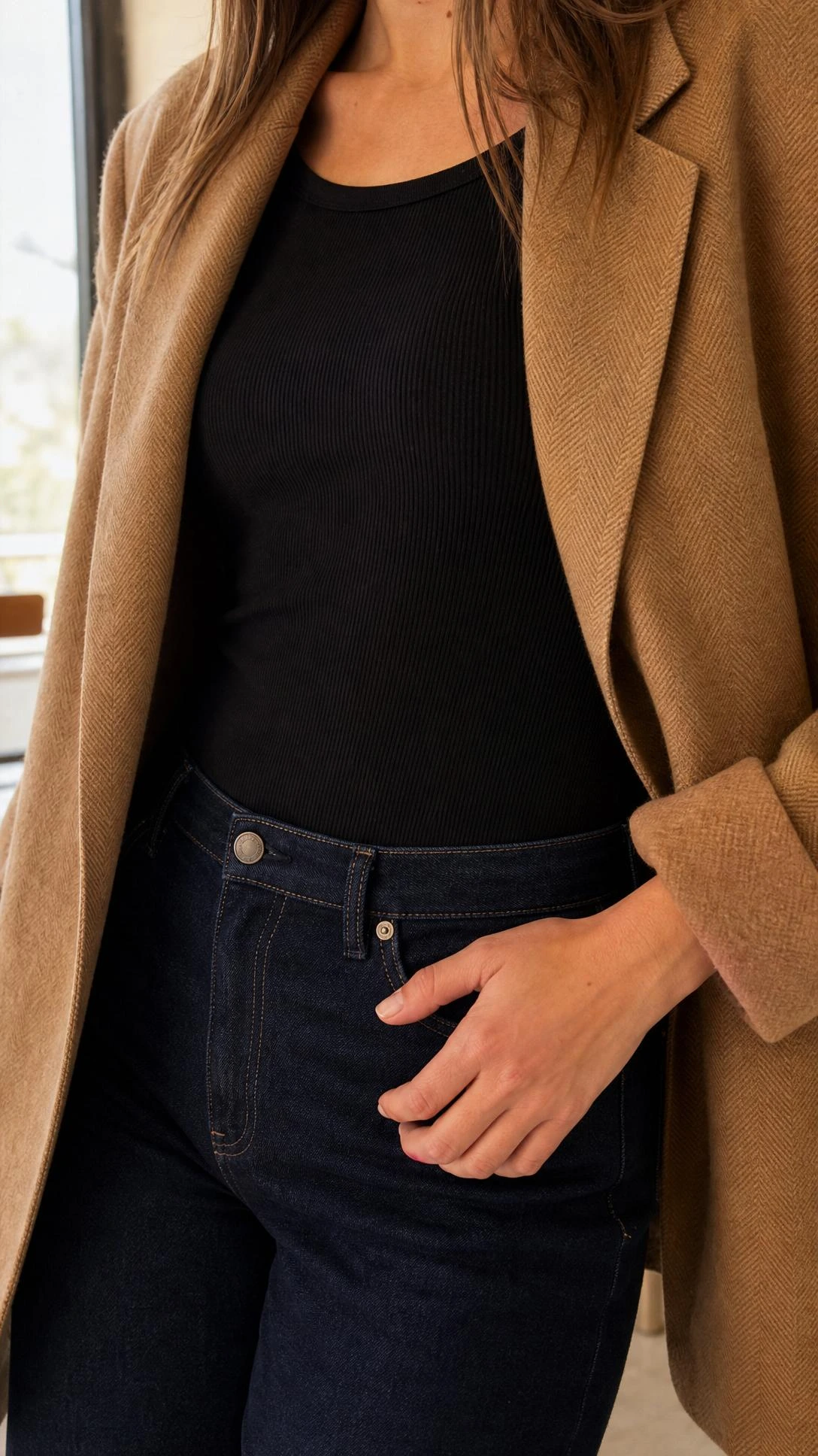 Caramel herringbone blazer worn open over a black ribbed bodysuit tucked into high-waist indigo jeans — a polished brunch outfit with effortless structure