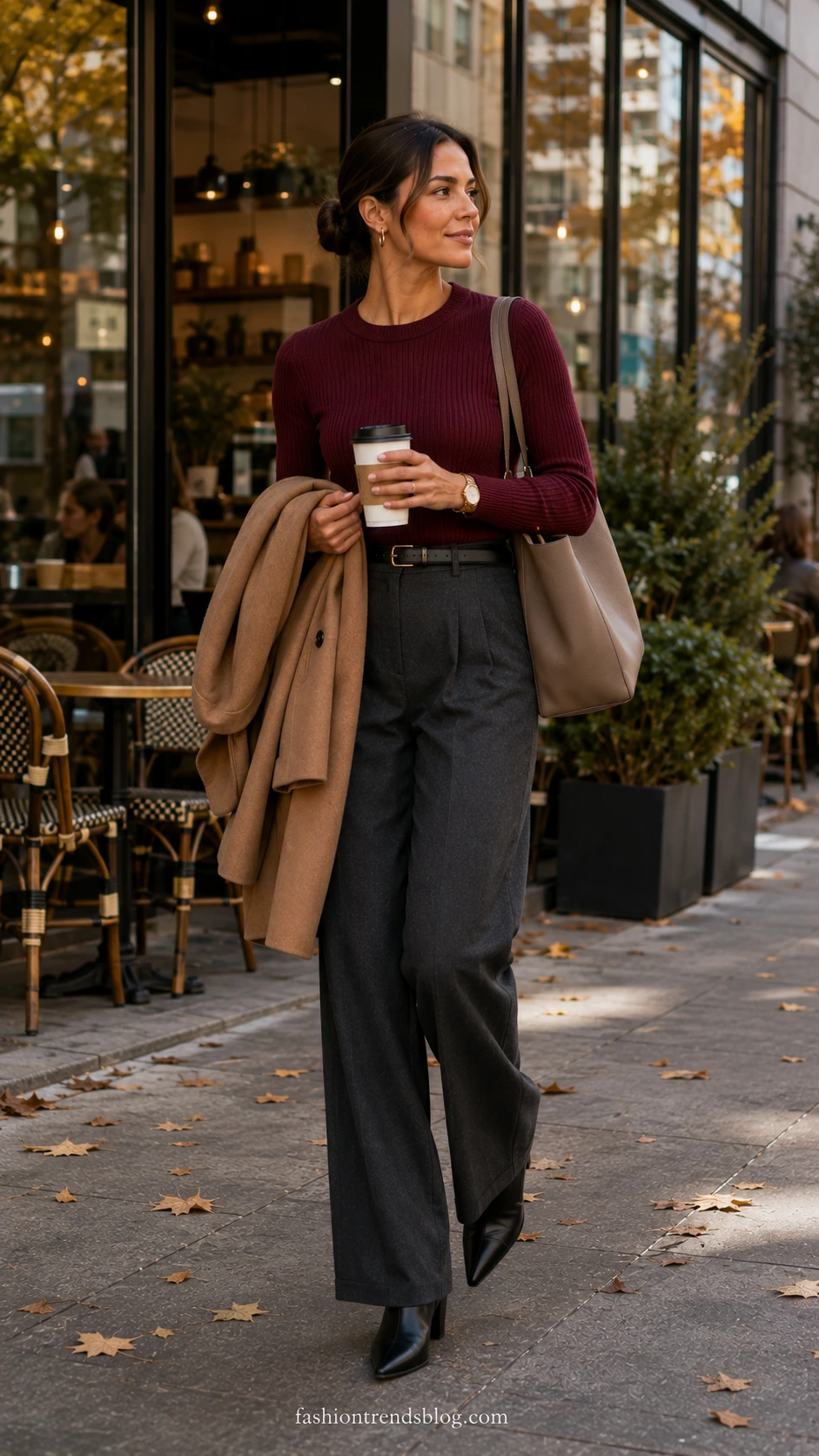 Woman walking by a city café in a burgundy ribbed sweater, charcoal wide-leg pants, and black belt, a polished Fall Office Work Outfit
