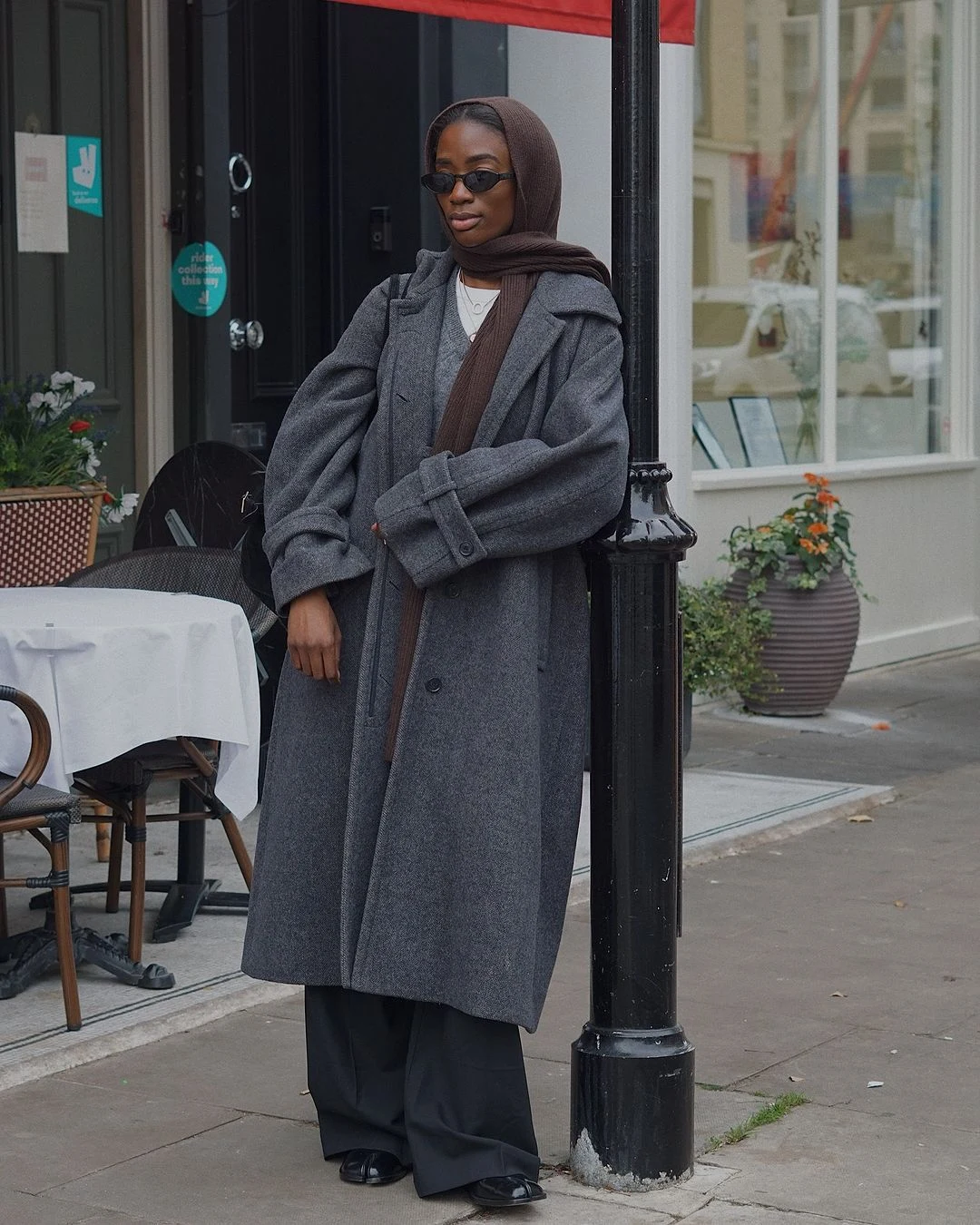 A polished winter outfit featuring a wool coat layered over a blazer and roll neck jumper.