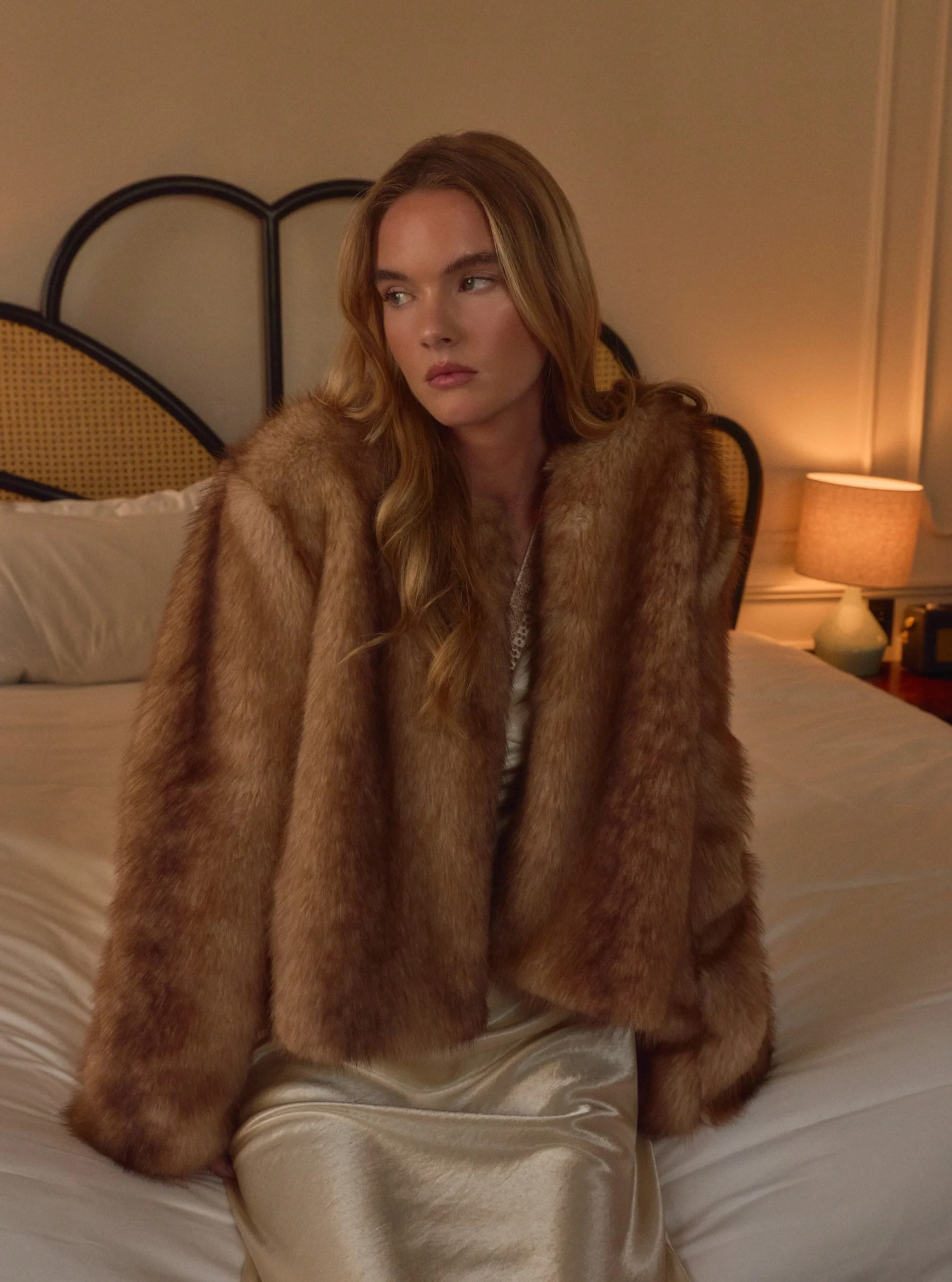 Voluminous brown fur jacket with wide lapels worn over a pale champagne satin slip dress.