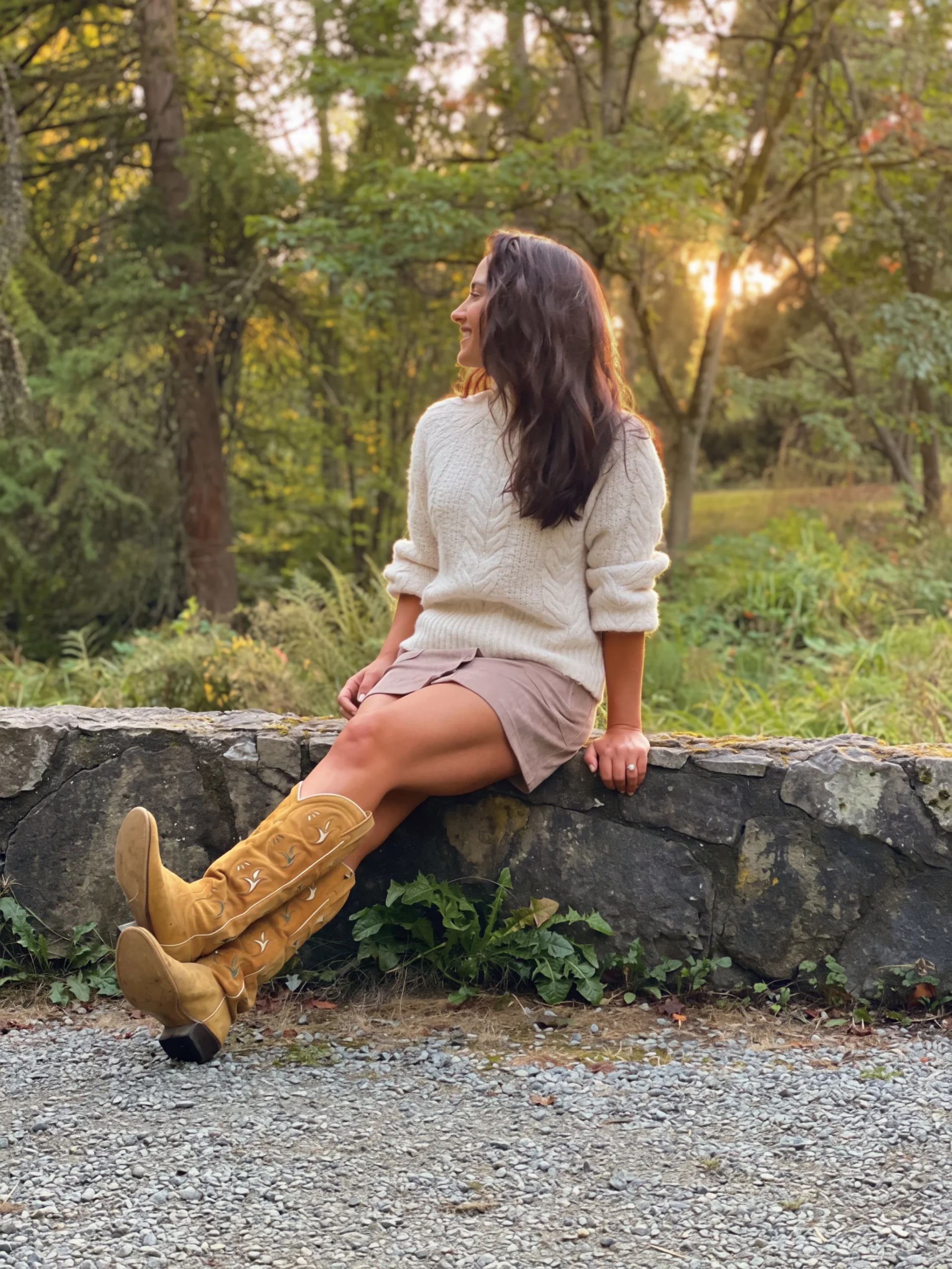Woman wearing a cream cable knit sweater, suede mini skirt, and mustard yellow cowboy boots.