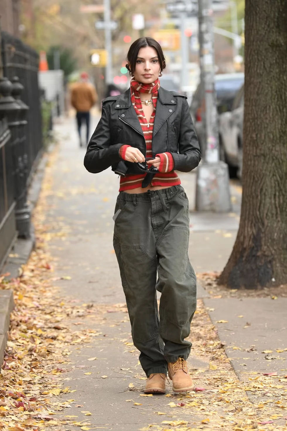 Emily Ratajkowski walking in New York wearing a long coat and boots in December.