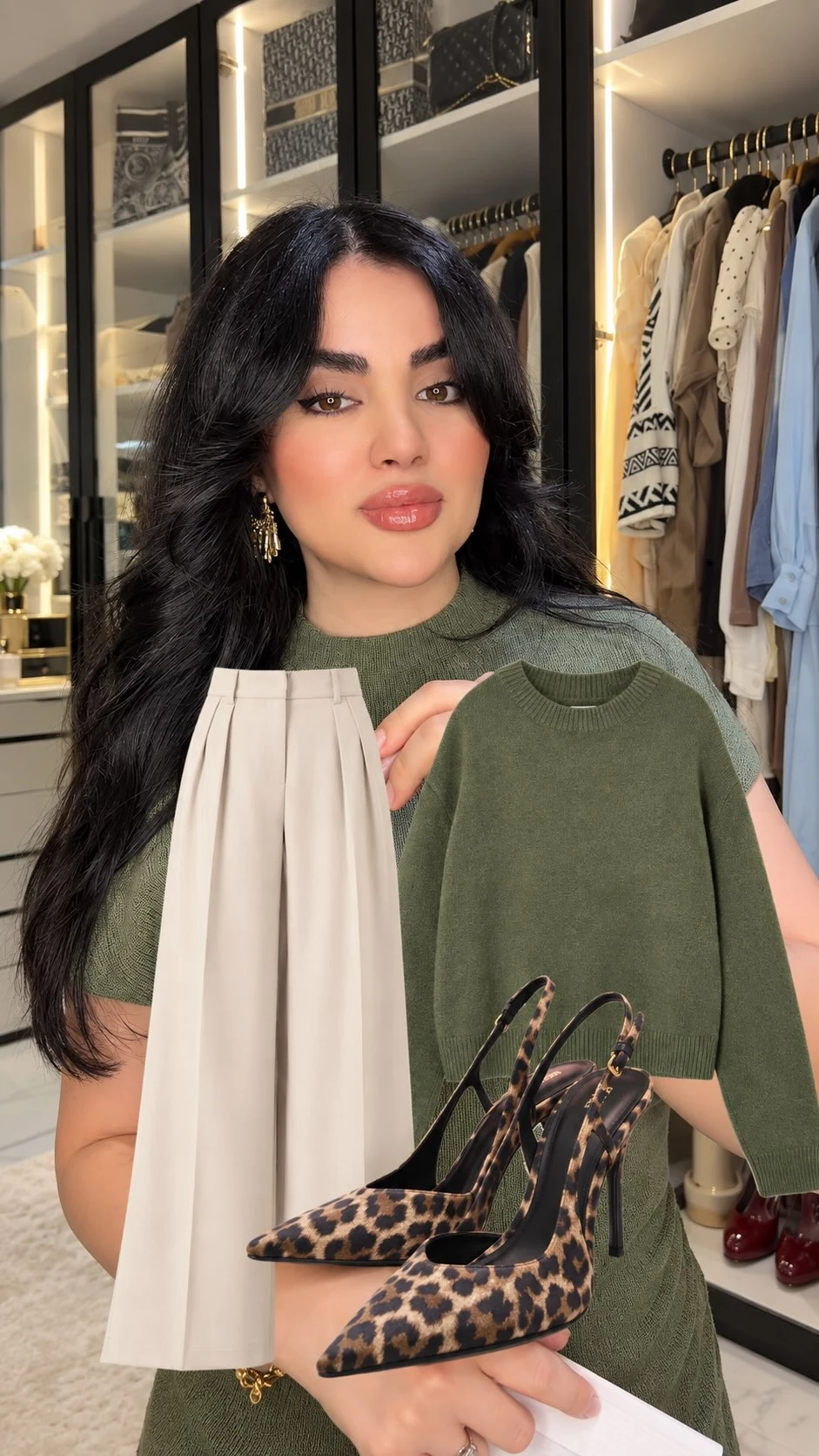 Olive green knit top styled with cream pleated trousers and leopard-print pointed-toe heels.