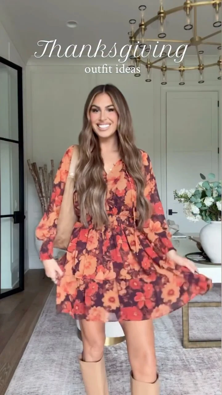 Woman wearing a red-orange floral long-sleeve mini dress with tan knee-high boots.