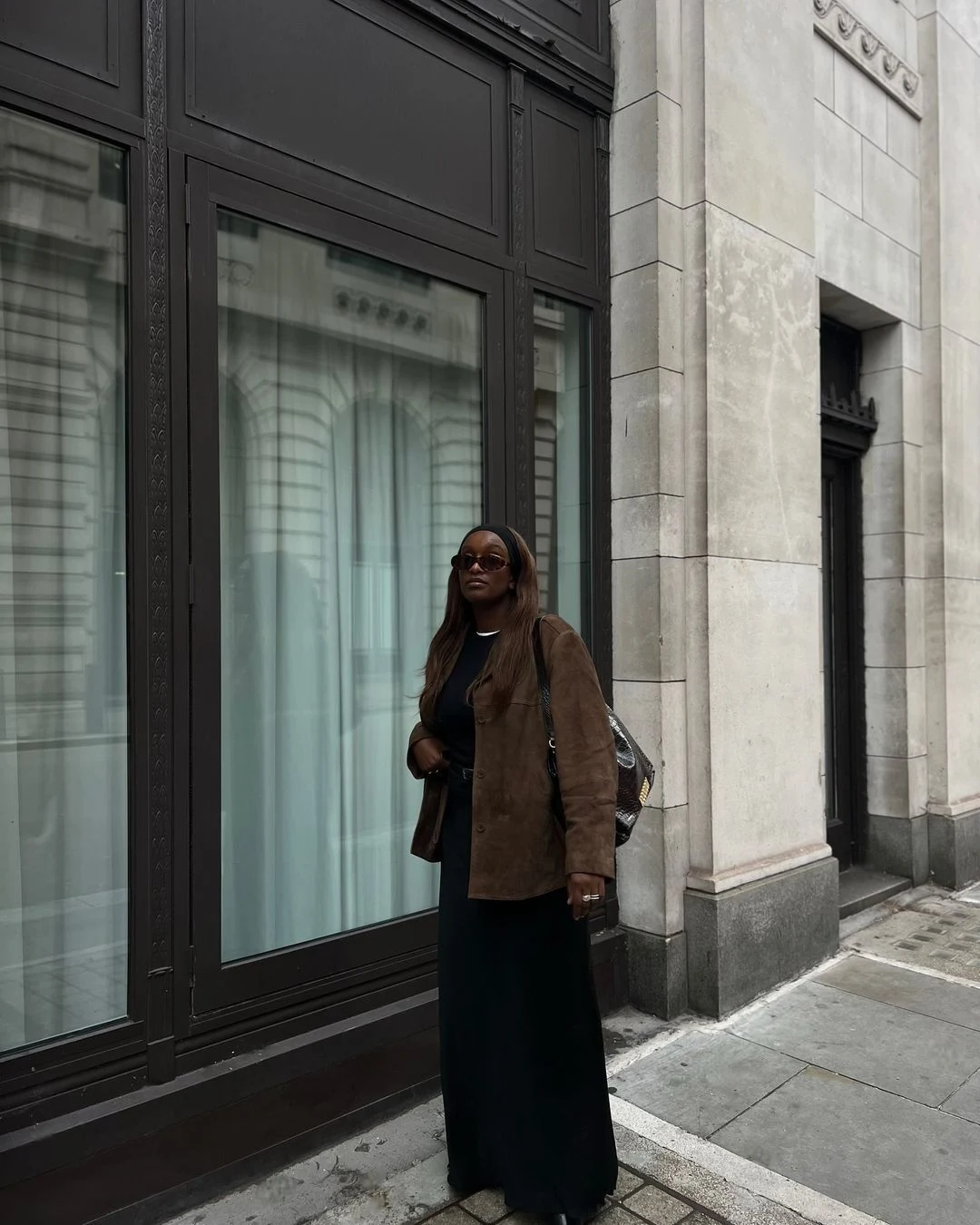 A suede jacket styled over a flowing maxi skirt for a chic winter outfit.