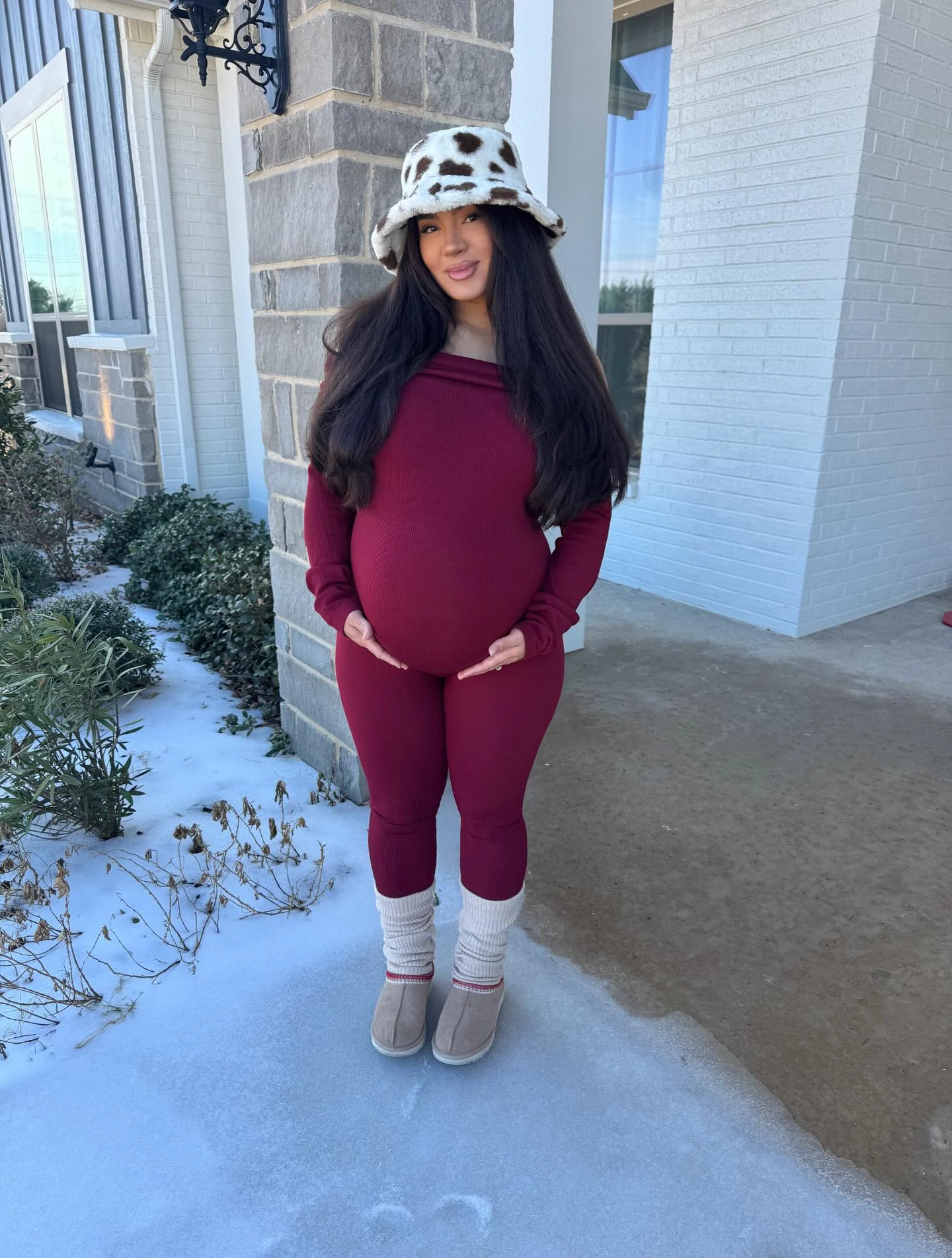 Person in burgundy matching set, spotted white bucket hat, white leg warmers, and gray boots.
