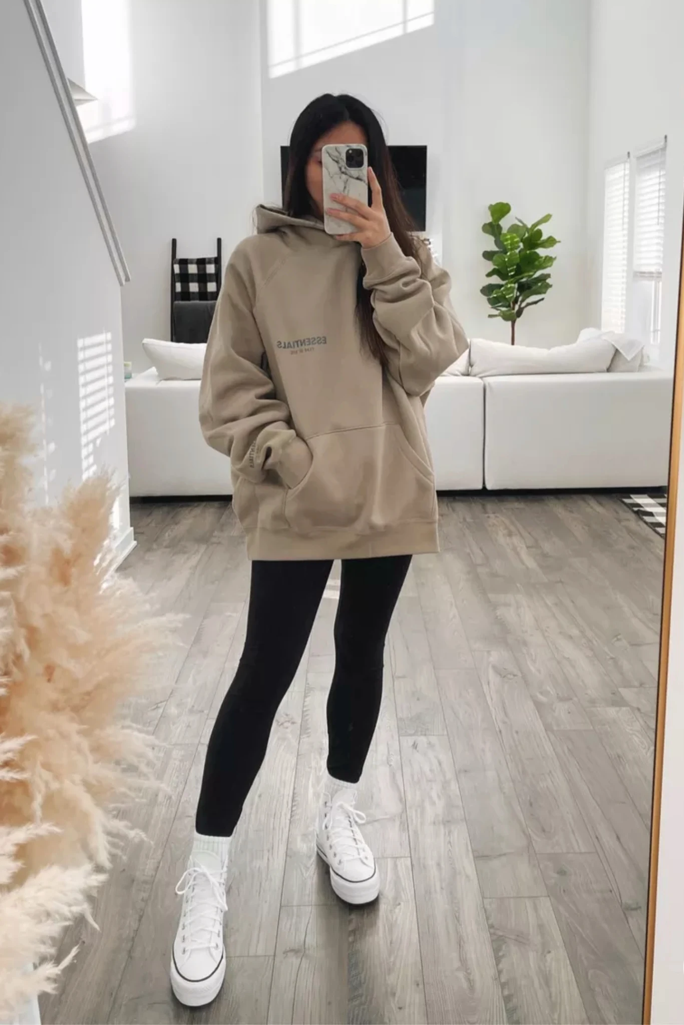 Person wearing an oversized hoodie styled with casual bottoms and sneakers for a relaxed look.