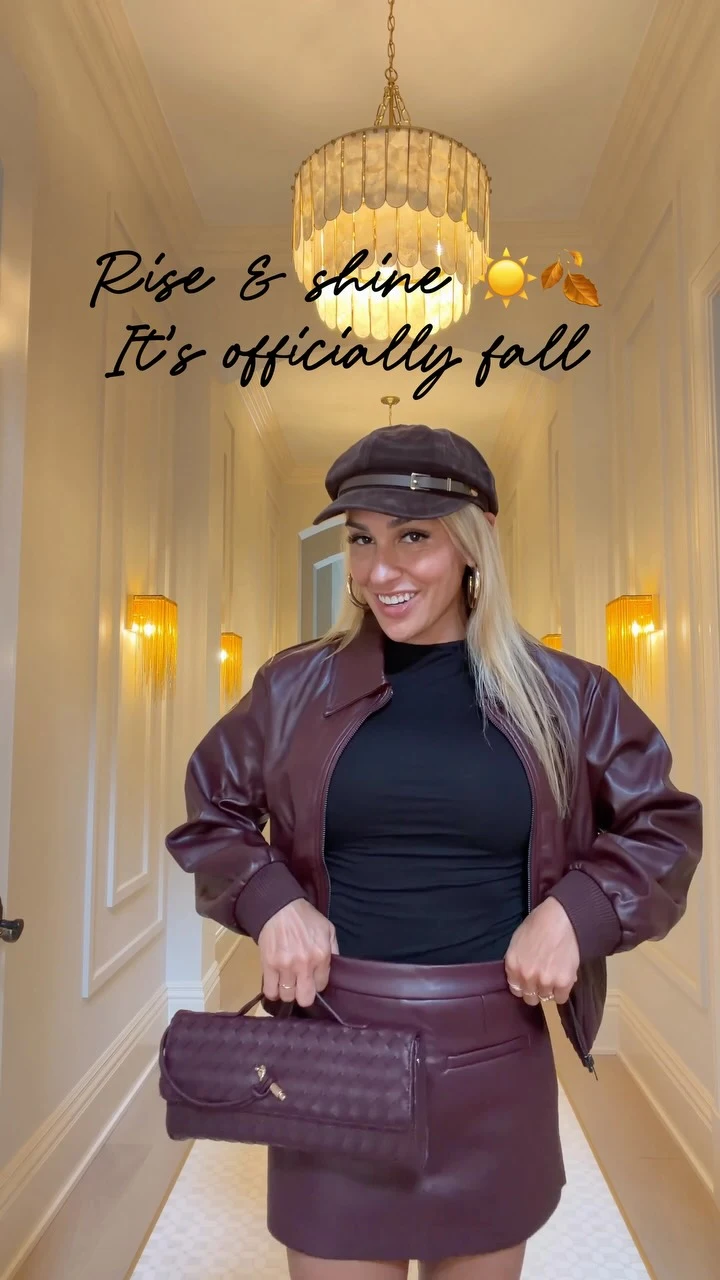 Burgundy leather-look matching jacket and mini skirt with black top, dark cap, and quilted bag.