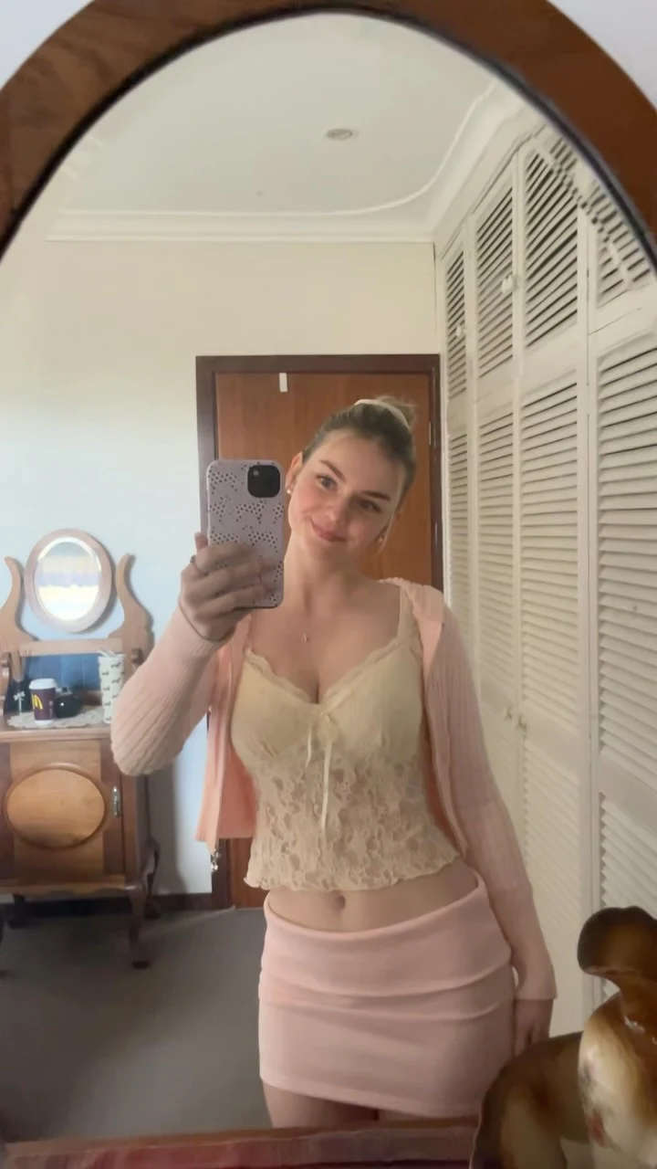 Cream lace-up corset crop top styled with a fitted light pink mini skirt.