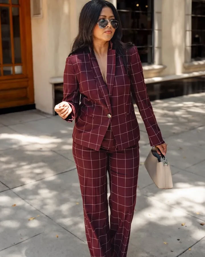 Petite woman wearing a fitted blazer and slim tailored trousers for winter work.
