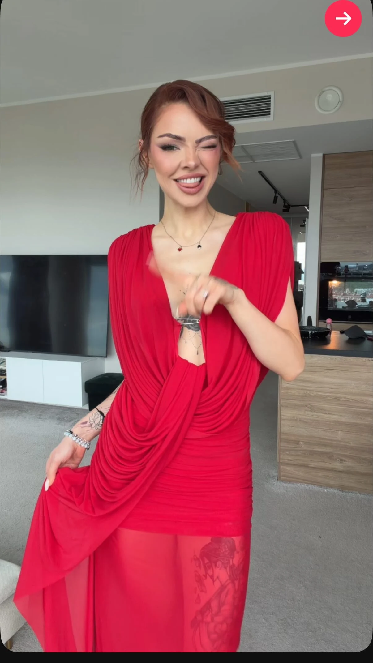 Woman wearing a bright red floor-length long-sleeve gown with a plunging draped V-neckline.