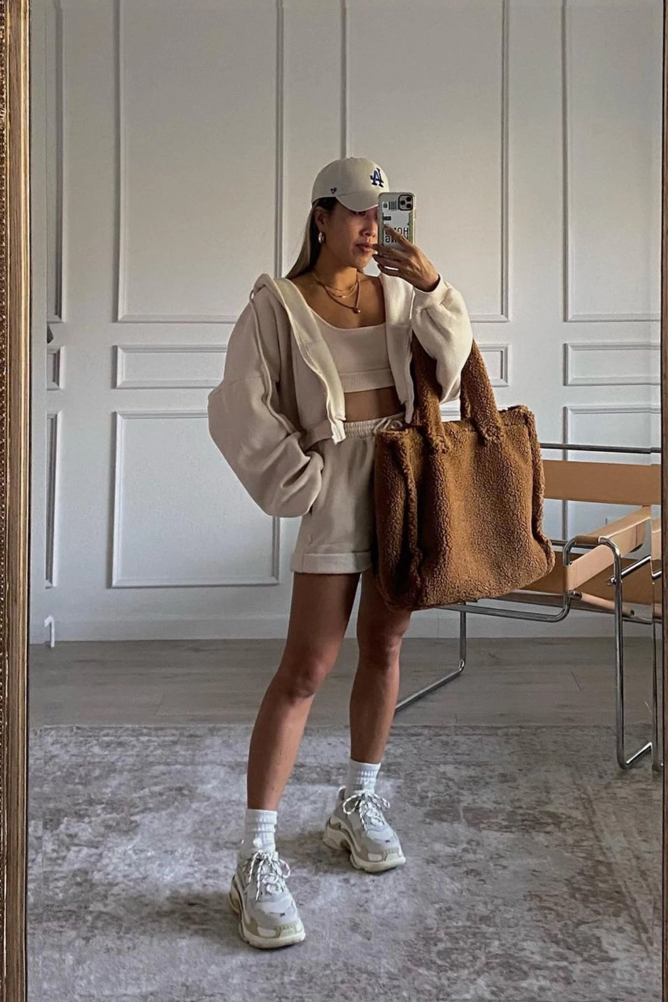 Woman wearing a casual hoodie outfit styled with sneakers and relaxed bottoms.