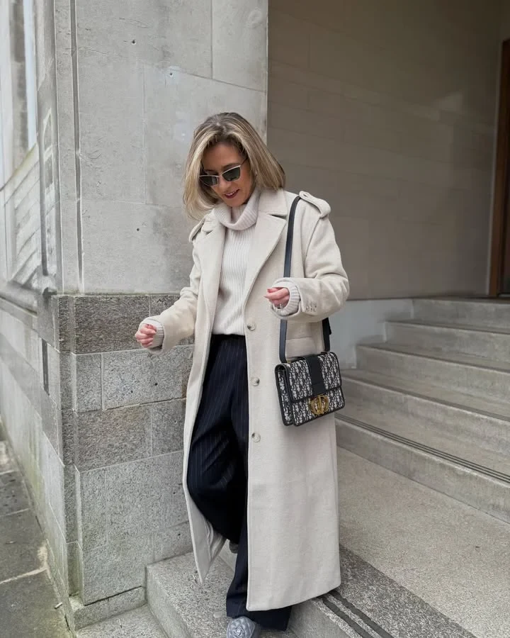 Petite woman wearing a tailored coat and slim trousers for a polished winter work look.