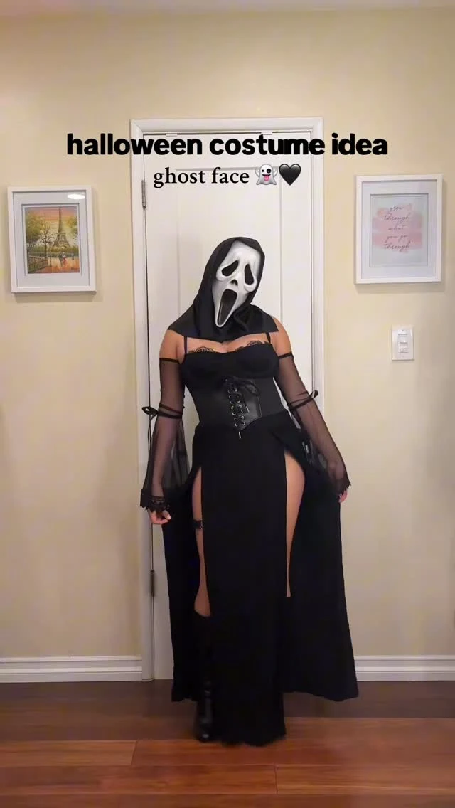Woman wearing a white sweater, black slit maxi skirt, and a Ghostface mask.
