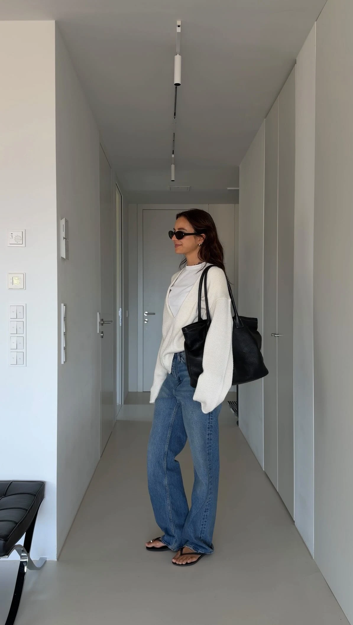 Oversized cream open cardigan over a white tee, medium blue straight jeans, and white sneakers.