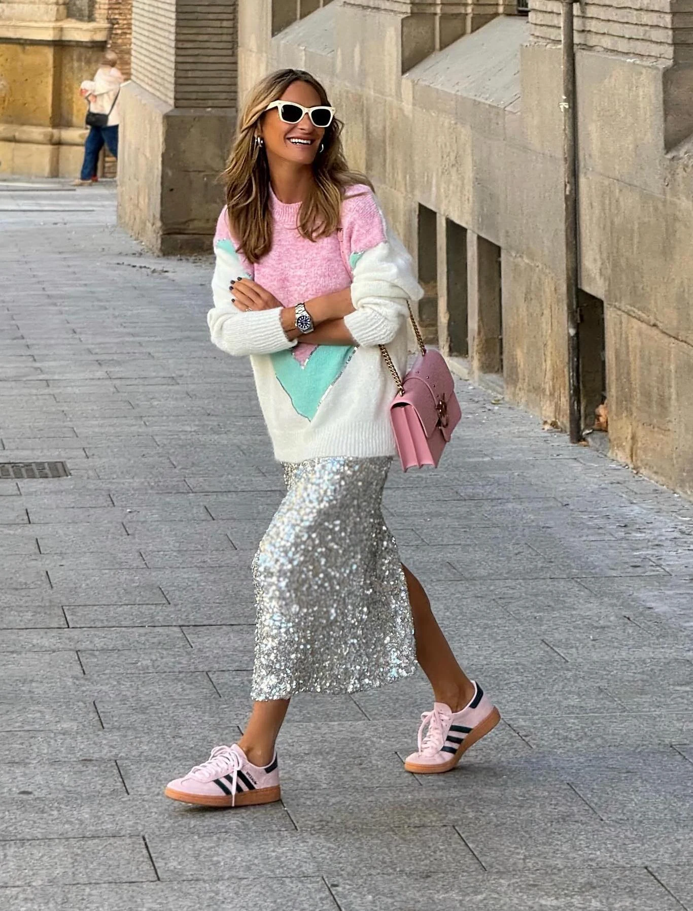 Silver midi skirt styled with a colorful oversized sweater and pink sneakers for a concert look.