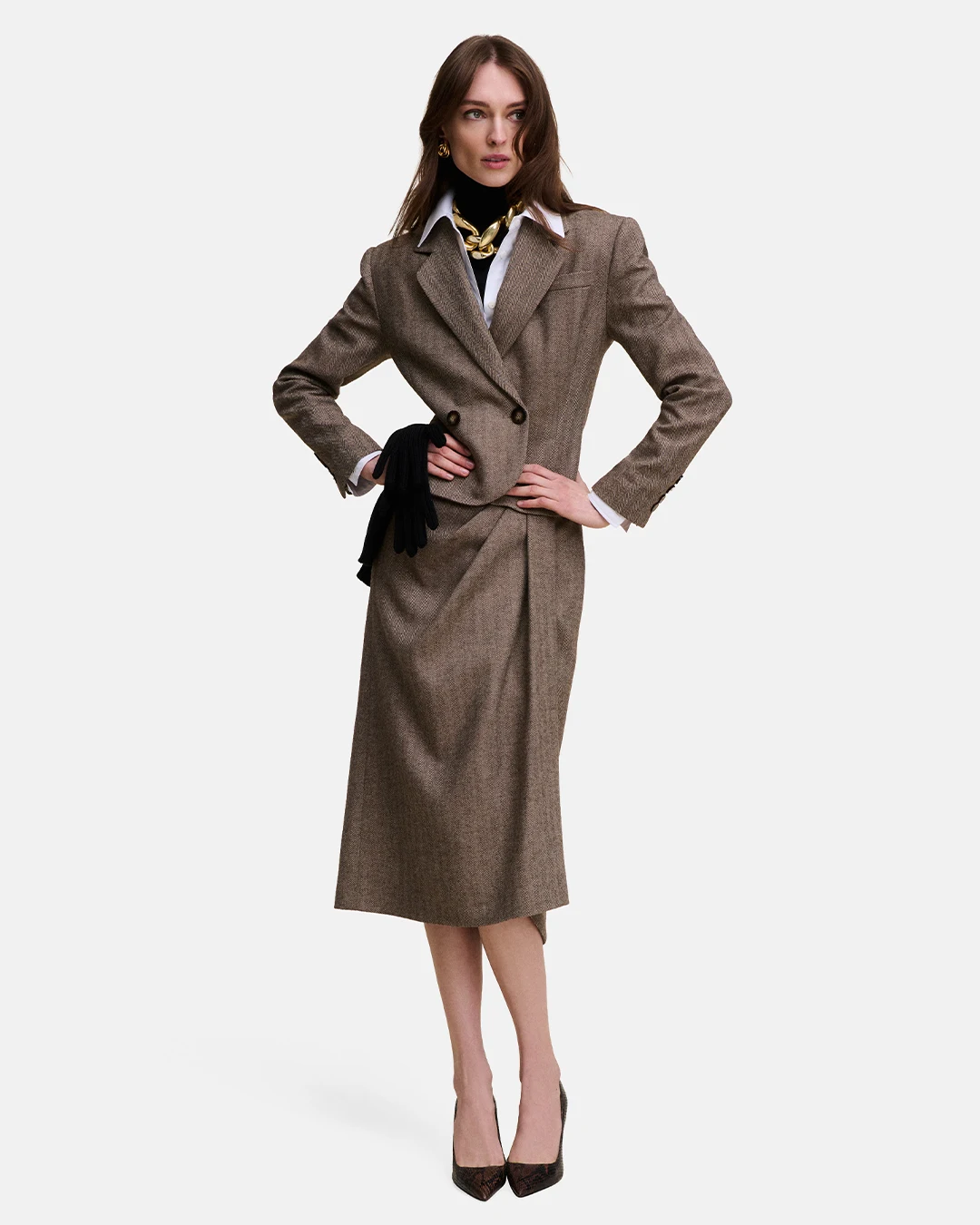 Brown herringbone blazer and midi skirt suit with a white shirt layered over a black turtleneck.