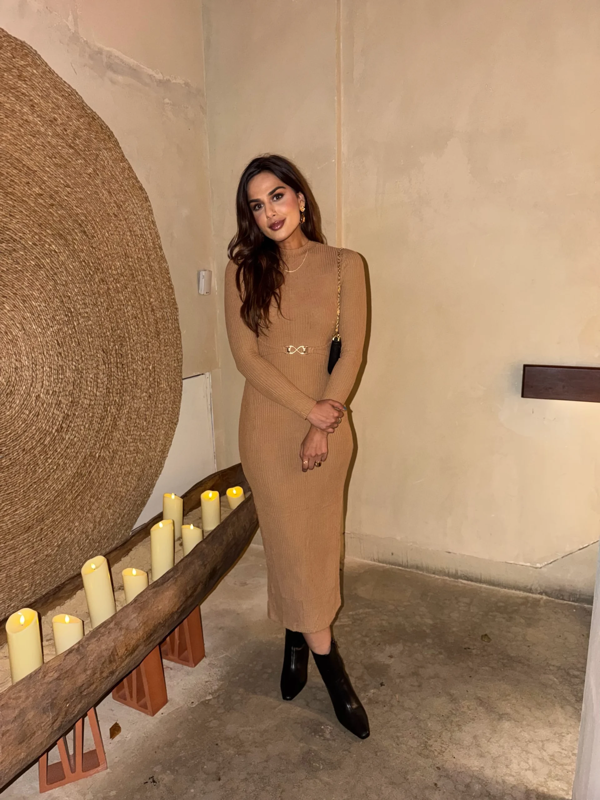 Camel ribbed midi dress with narrow belt, black pointed-toe block-heel boots, and chain-strap shoulder bag.