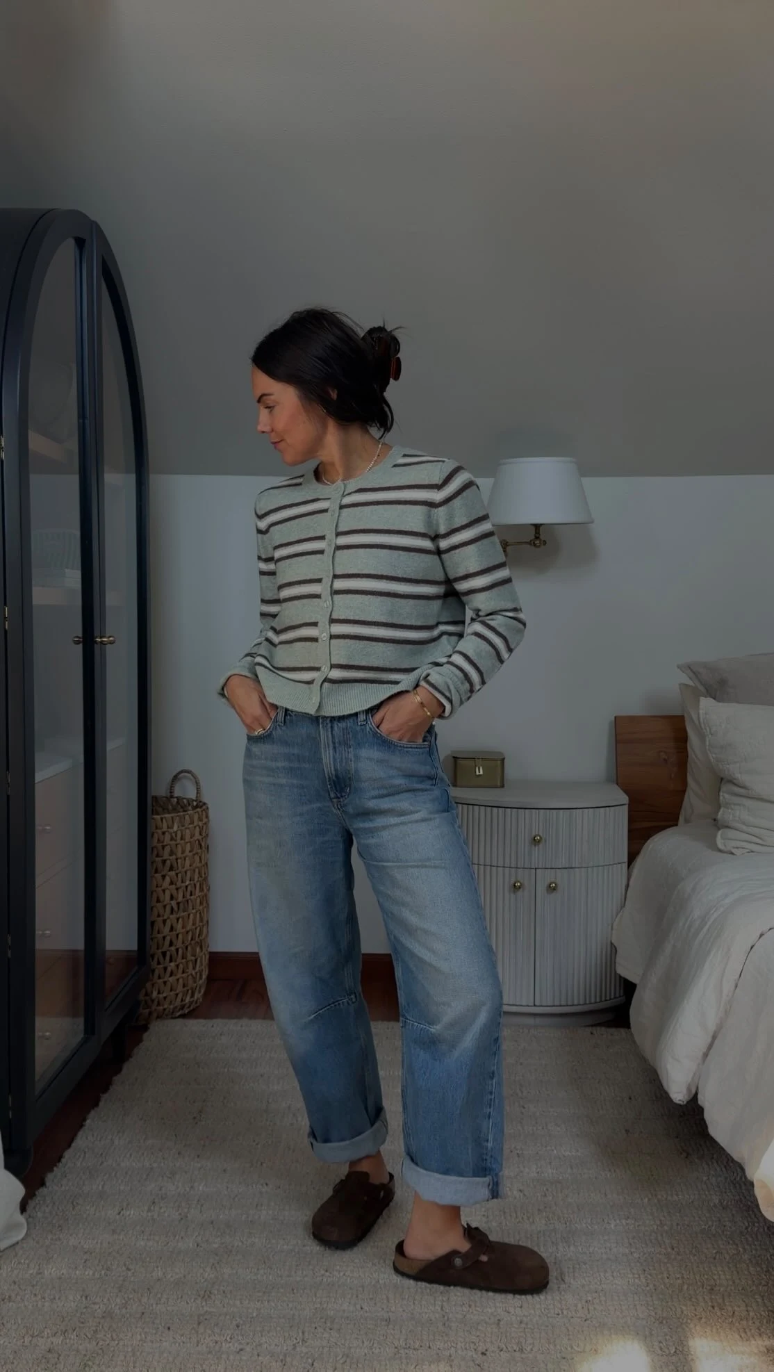 Mint green striped cardigan over a white top with dark denim jeans.