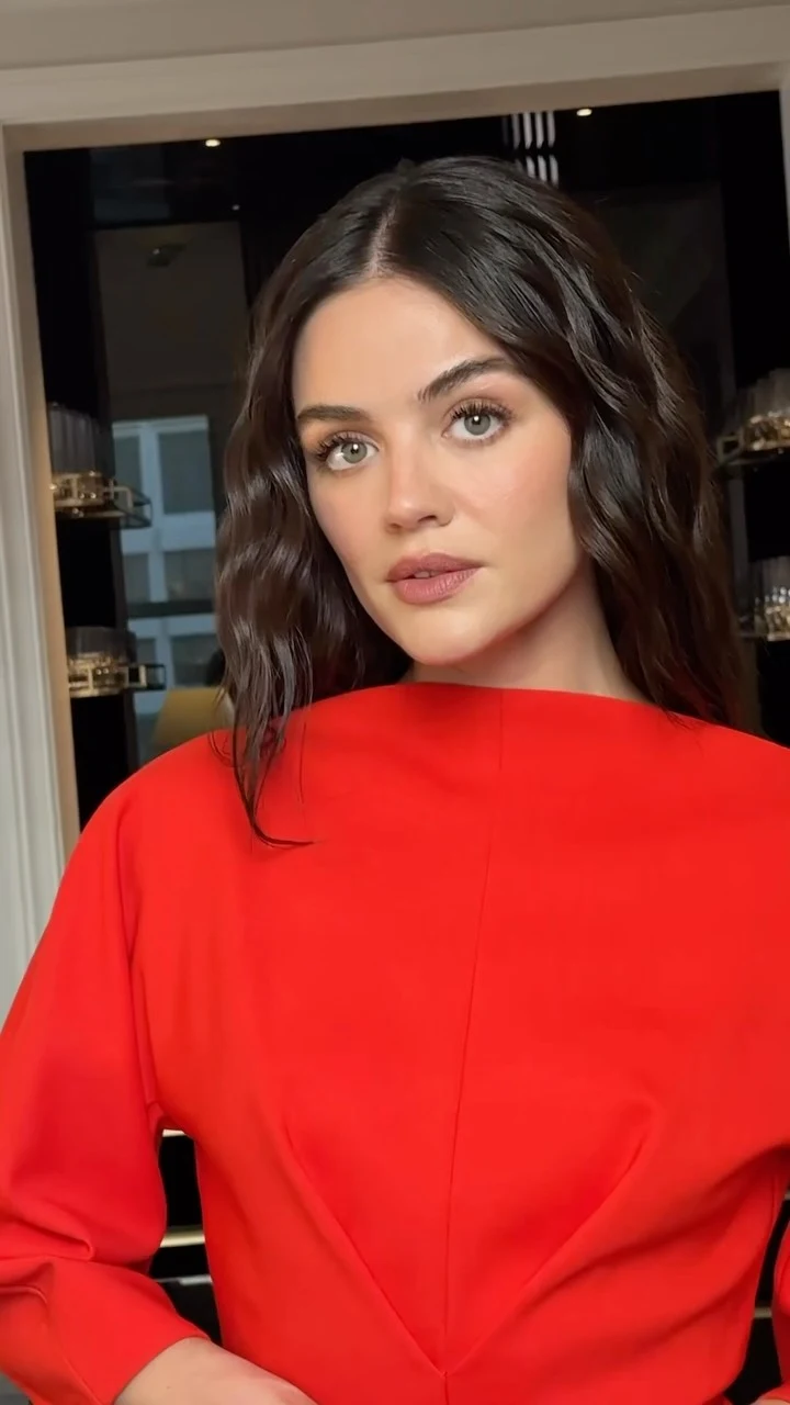 Person wearing a vivid red long-sleeve top with a wide neckline and shaping seams at the waist.
