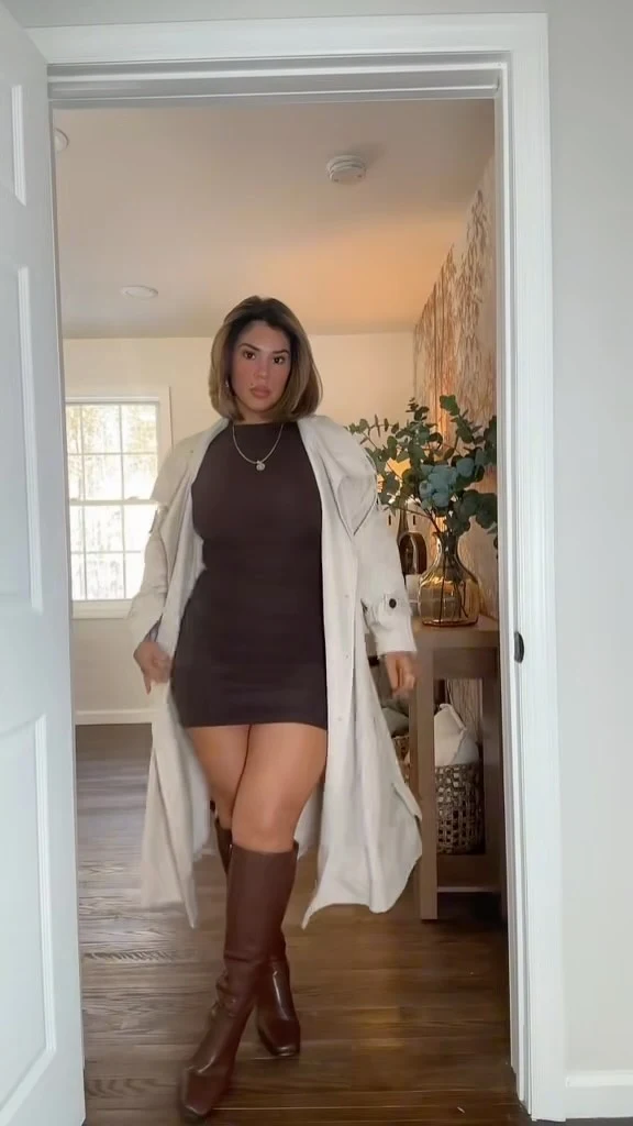 Dark brown mini dress and knee-high boots under a long cream trench coat with black leather gloves.
