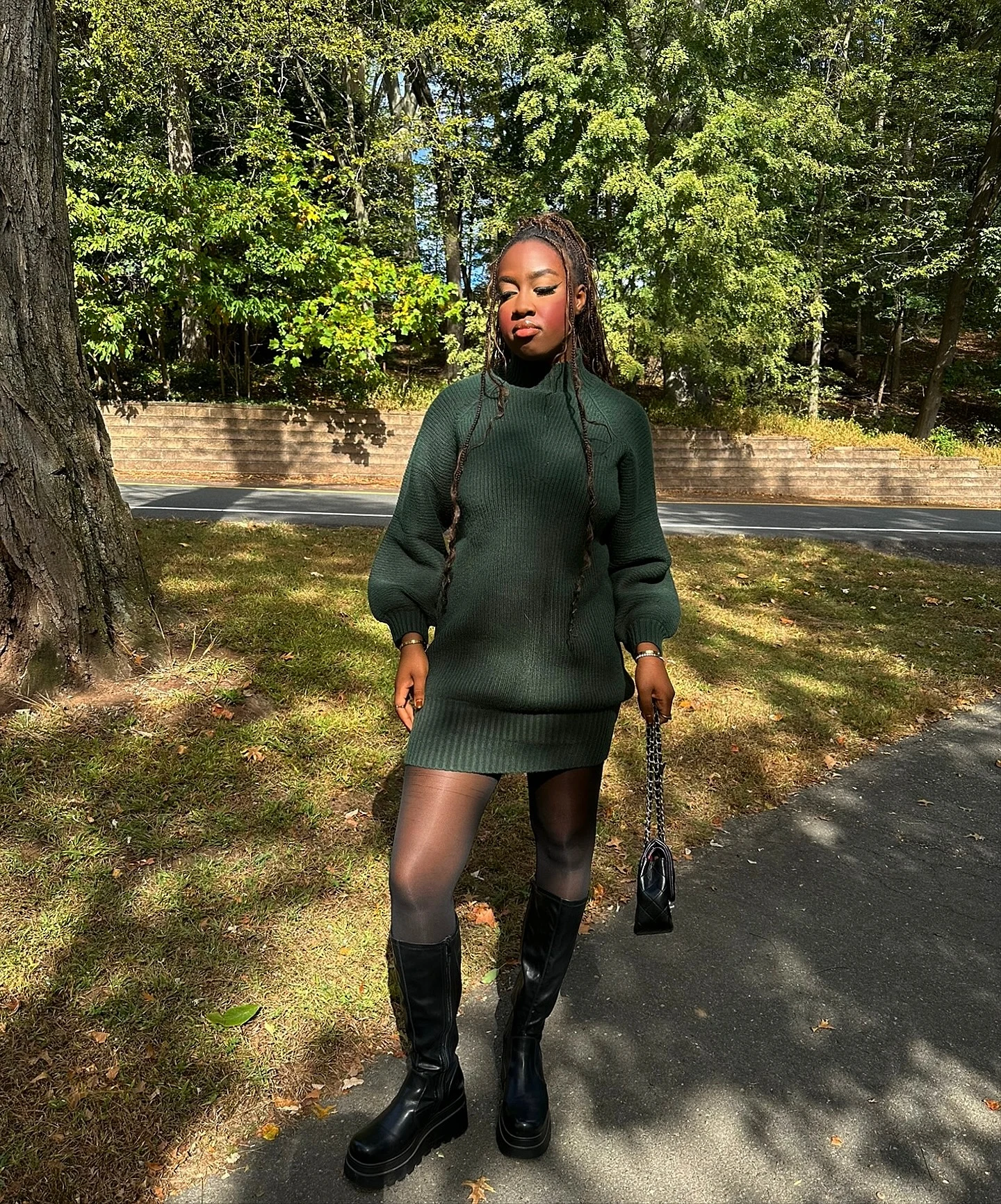 dark forest-green ribbed turtleneck sweater dress to mid-thigh, sheer black tights, black knee-high platform boots, black quilted chain bag