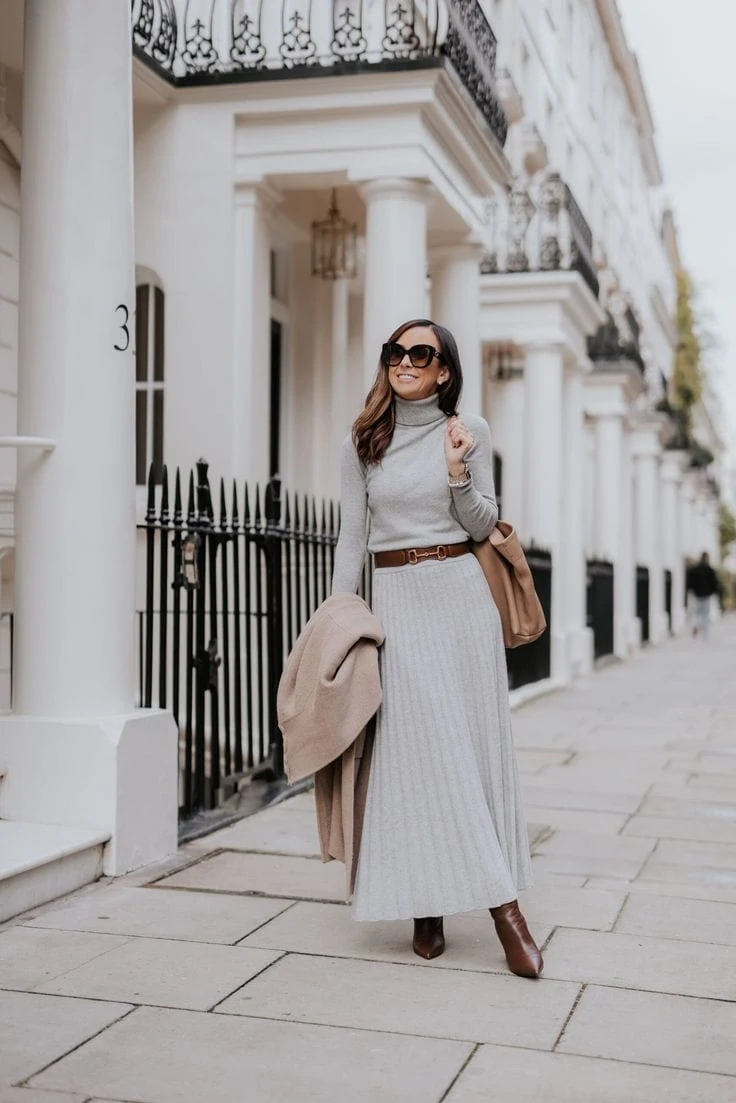 A ribbed gray maxi dress paired with brown ankle boots and a matching brown belt creates a clean and elegant silhouette. The neutral tones make it a versatile choice for any winter day.