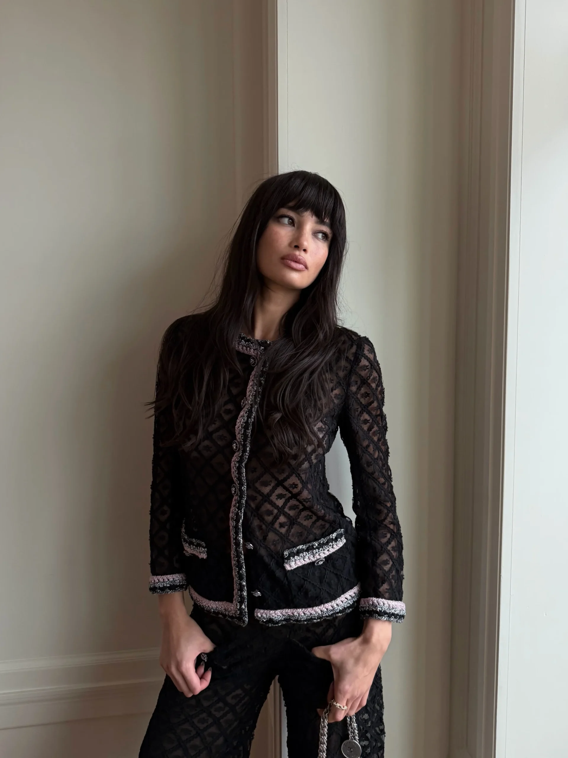 Fitted black diamond-pattern jacket and matching trousers with pale textured trim detailing.