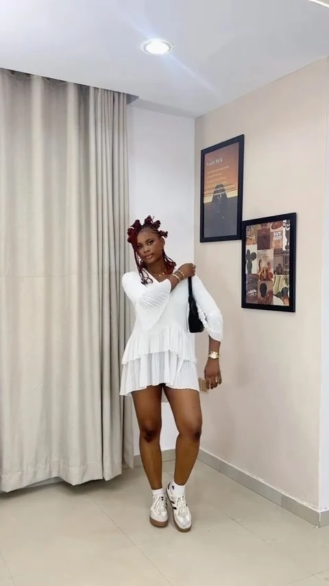 Black sleeveless top and mini skirt paired with white Adidas Sambas.