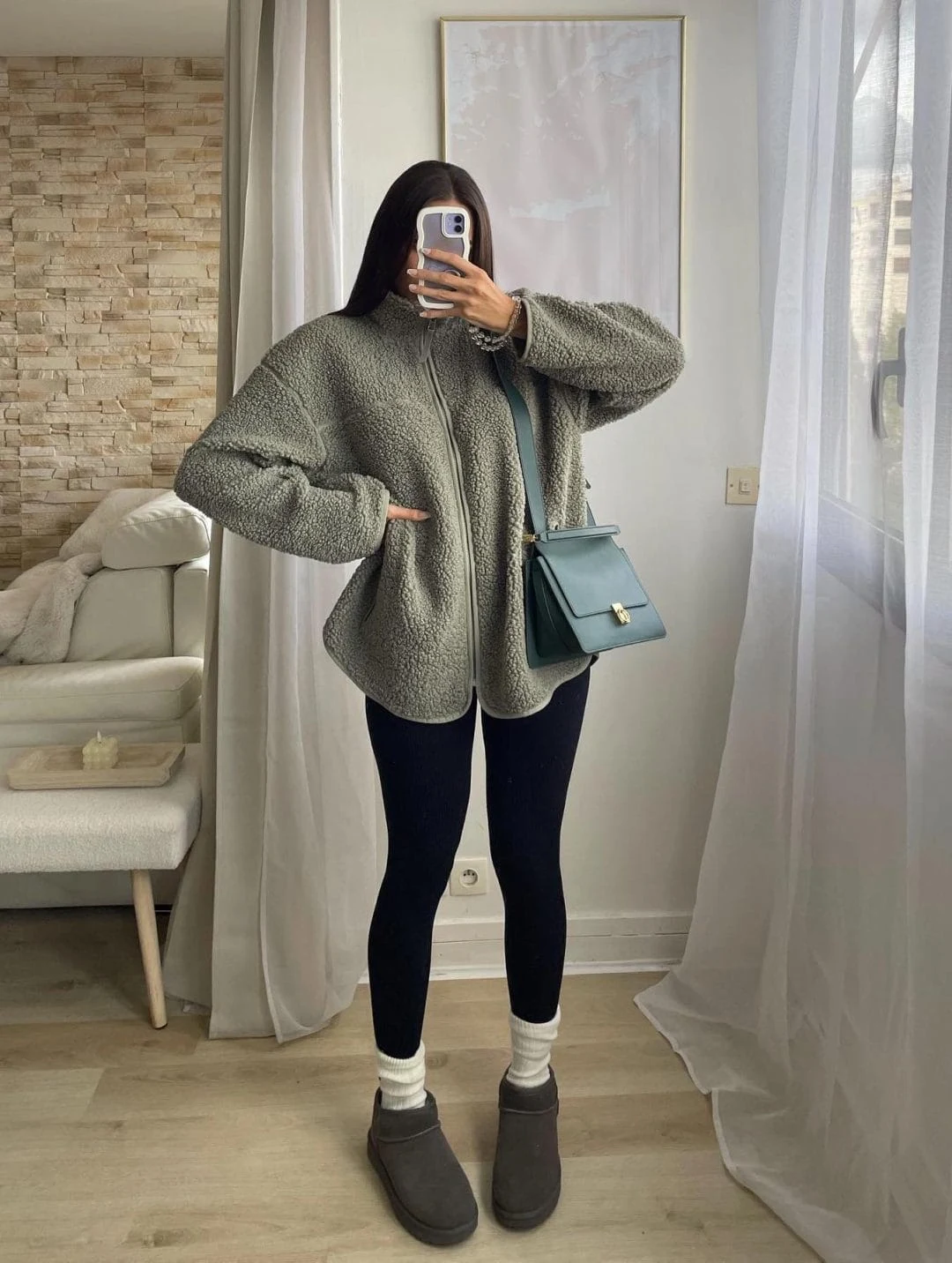 Green sherpa jacket, black ribbed leggings, grey mini boots, and blue crossbody bag for a cozy cold-day look.