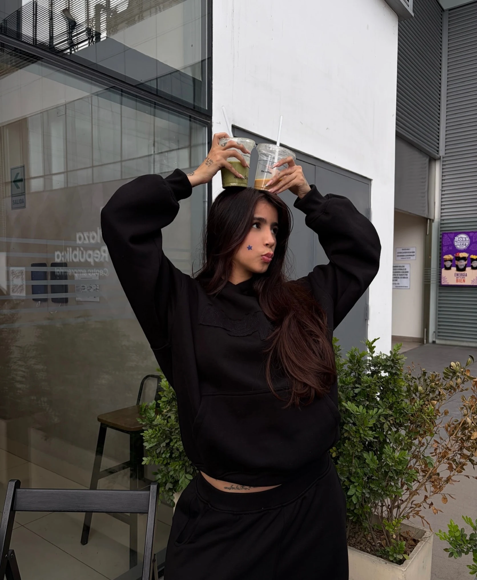 Person wearing a cropped black hoodie and matching black sweatpants in a relaxed fit.