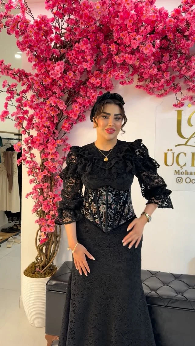Black lace long-sleeve top with ruffled detailing and embroidered corset bodice, matching lace skirt