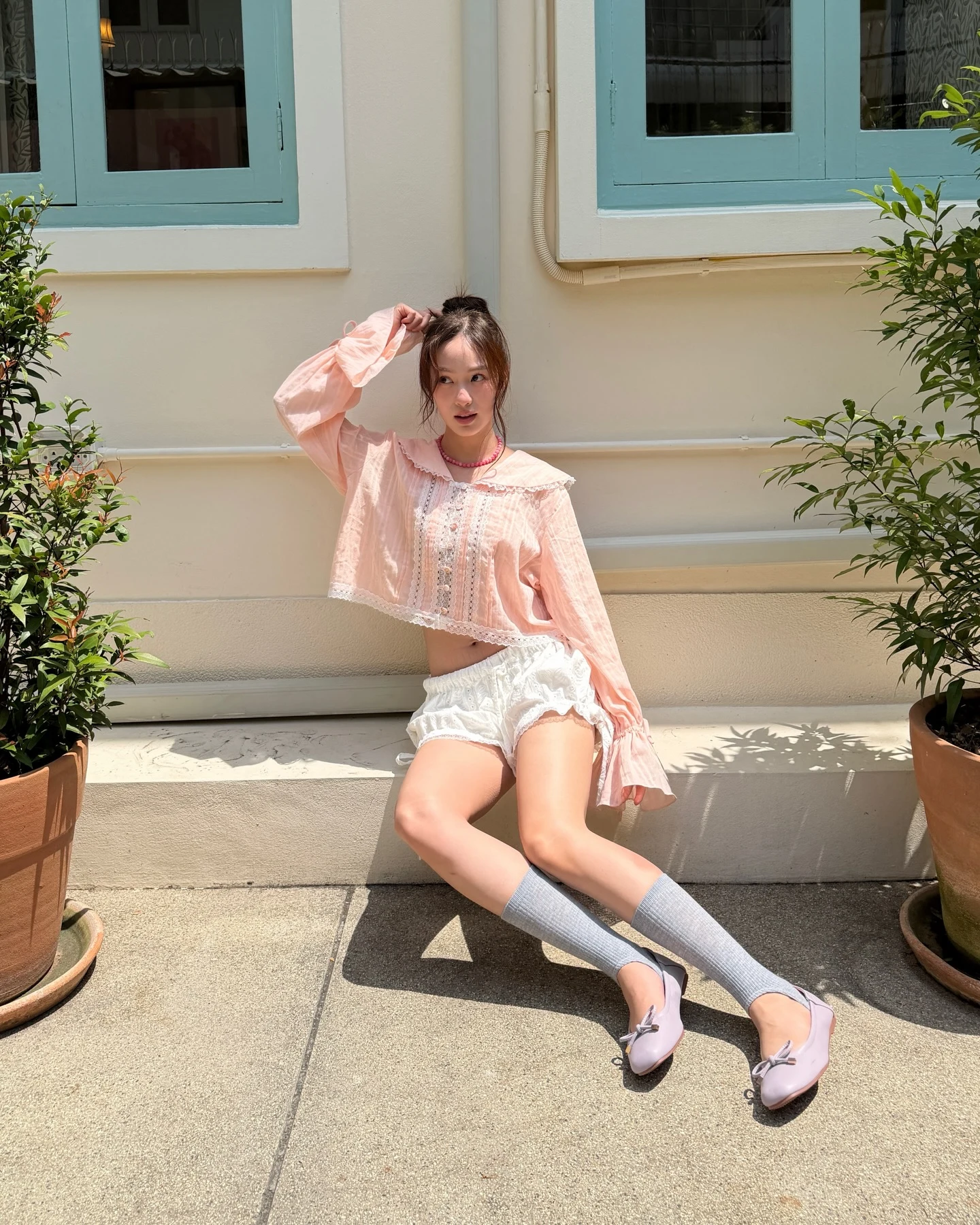 Pink lace crop top with white eyelet shorts, gray knee-high socks, and lavender ballet flats.