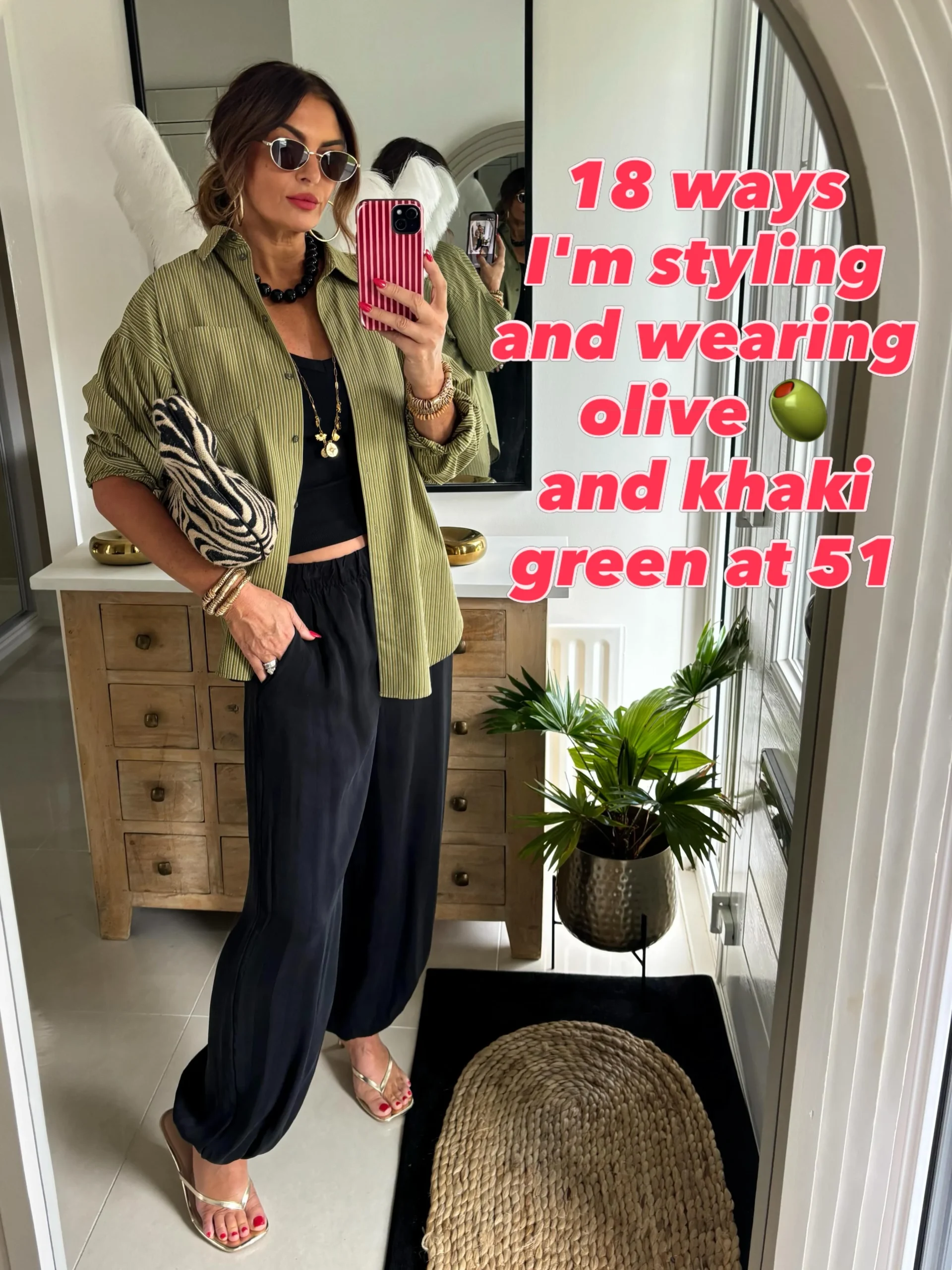 Olive striped shirt layered over a black crop top and wide-leg trousers with metallic strappy sandals.