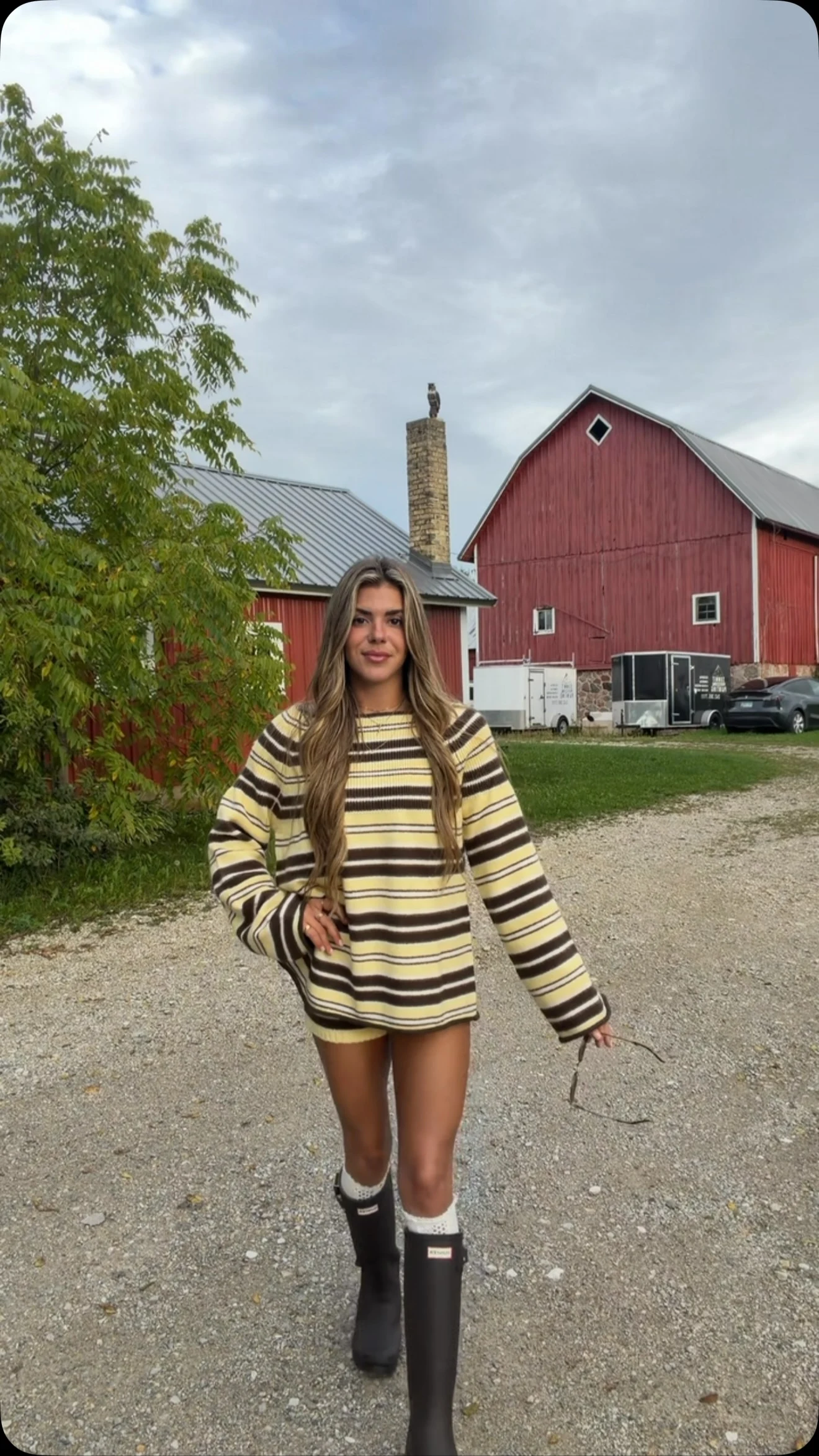 Oversized yellow and brown striped fuzzy knit sweater dress worn with tan knee-high boots.
