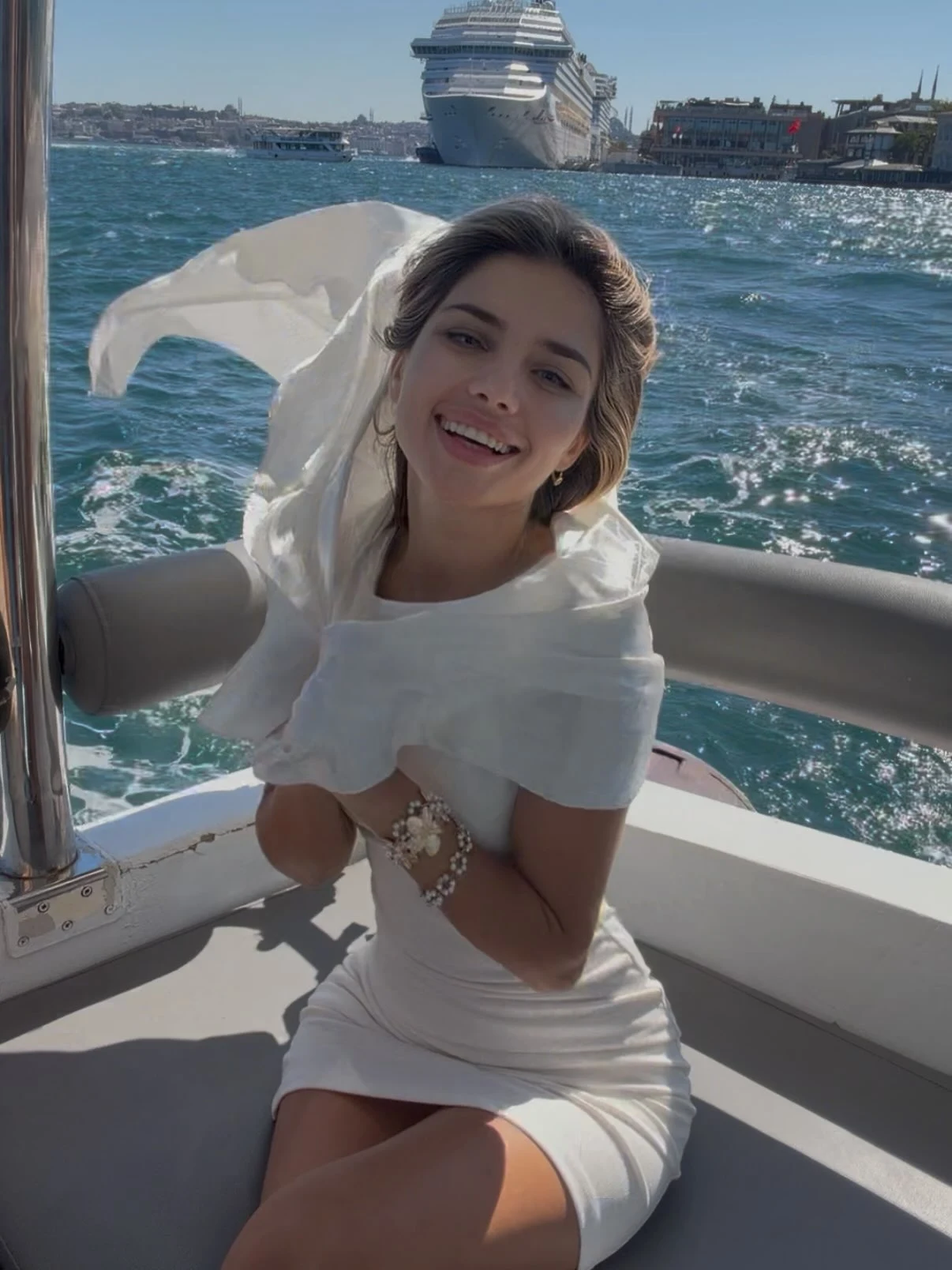 Woman in a crisp white sleeveless mini dress on a sunny cruise vacation.