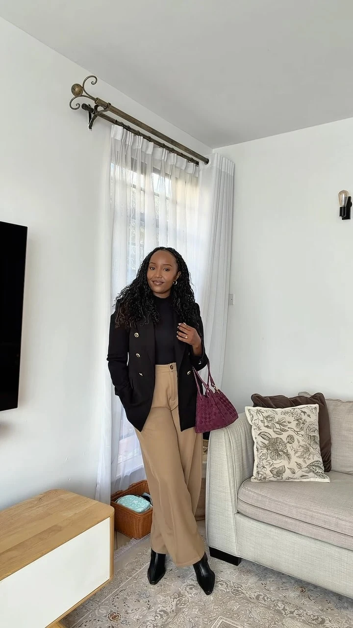 Black turtleneck and blazer paired with camel barrel pants, black boots, and a purple handbag.
