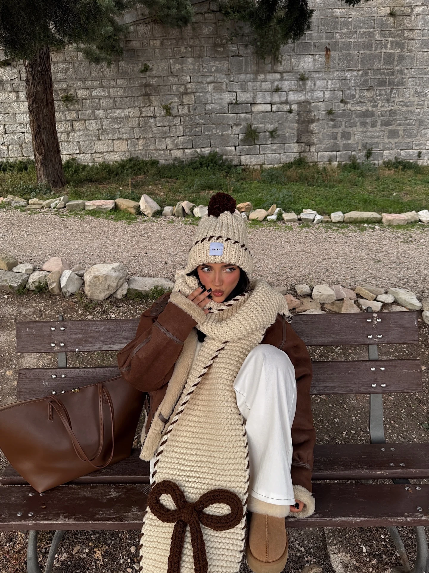 Cream oversized turtleneck and dark brown mini skirt styled with black tights and brown knee-high boots.