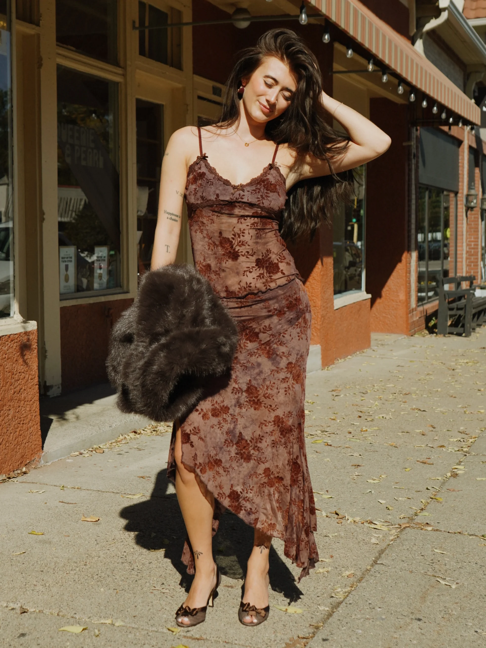Mauve floral slip dress with lace trim paired with a voluminous dark brown fur wrap and heels.