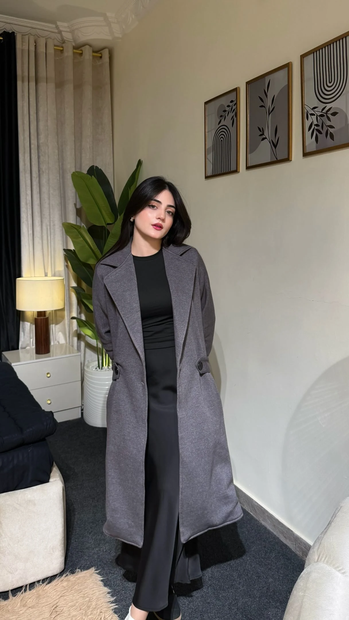 Grey wool coat layered over a black maxi dress with white sneakers and a black shoulder bag.