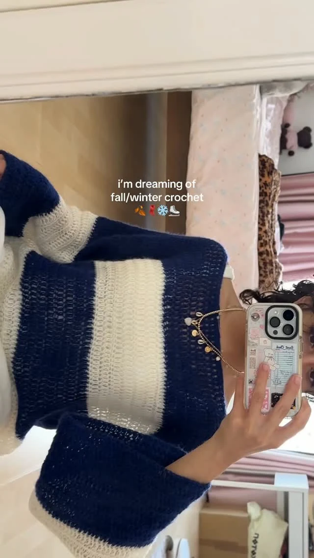 Loose navy and cream striped crochet sweater with open stitch and gold-tone chain detail.
