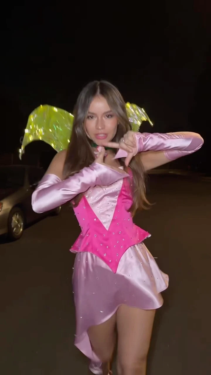 Pink satin mini dress layered with a studded corset bodice and long matching satin gloves.