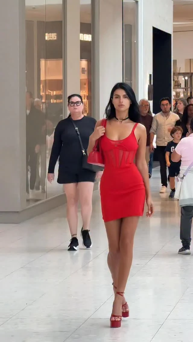 Woman in a fitted red mini dress with matching red platform sandals and a small red shoulder bag.