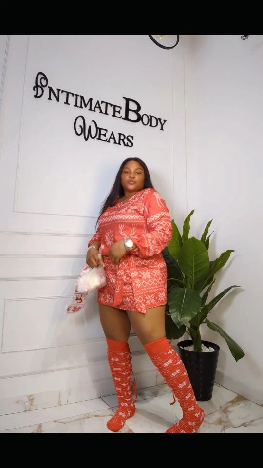Woman in a red geometric patterned tunic with matching over-the-knee socks and bare legs.