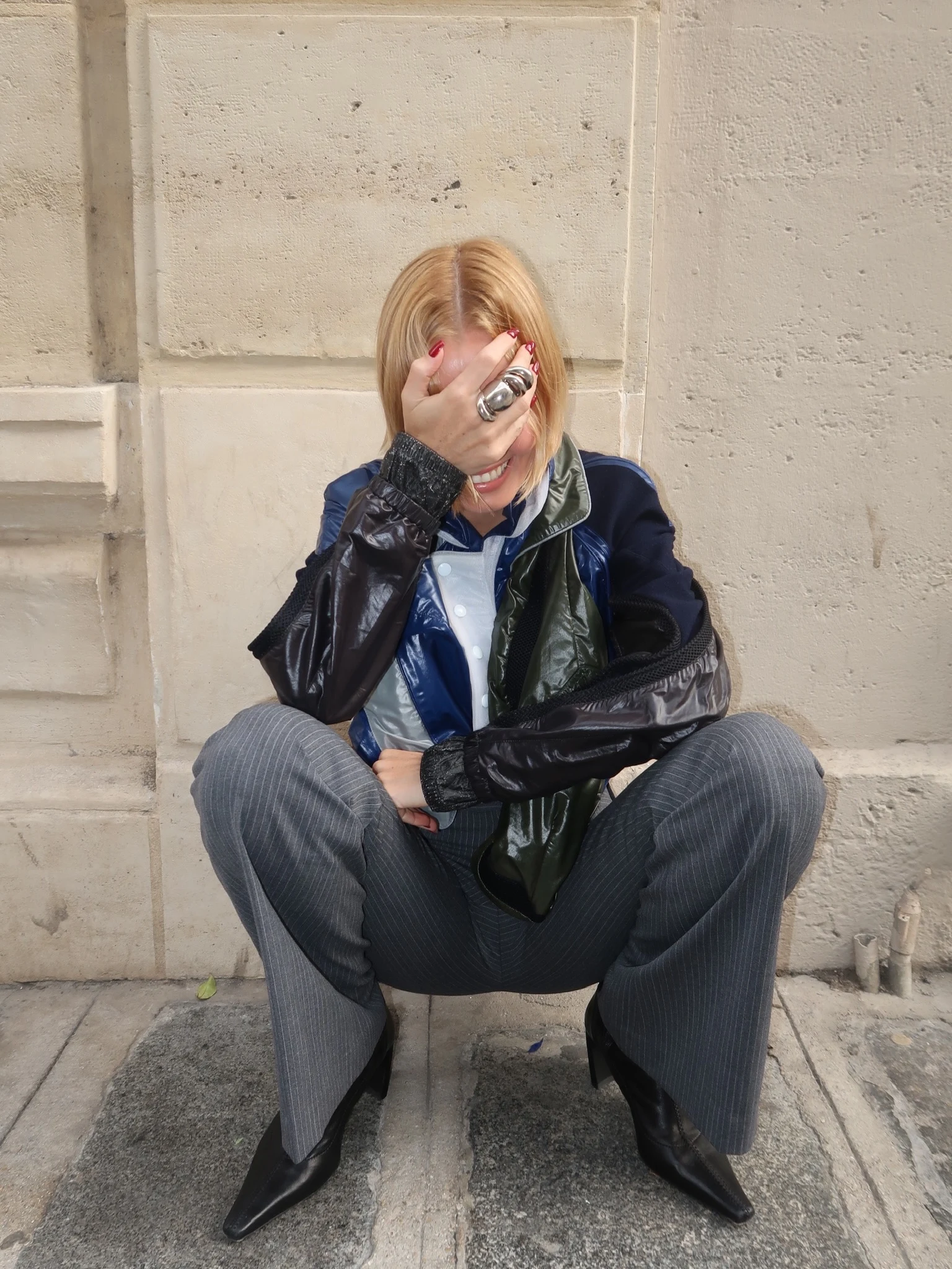 Glossy color block cropped jacket over pinstripe wide-leg trousers and black pointed-toe boots.