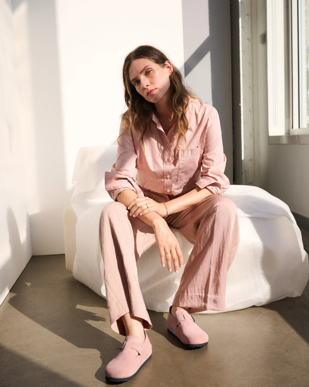 Person wearing a dusty pink matching wide-leg trouser set with suede clogs.