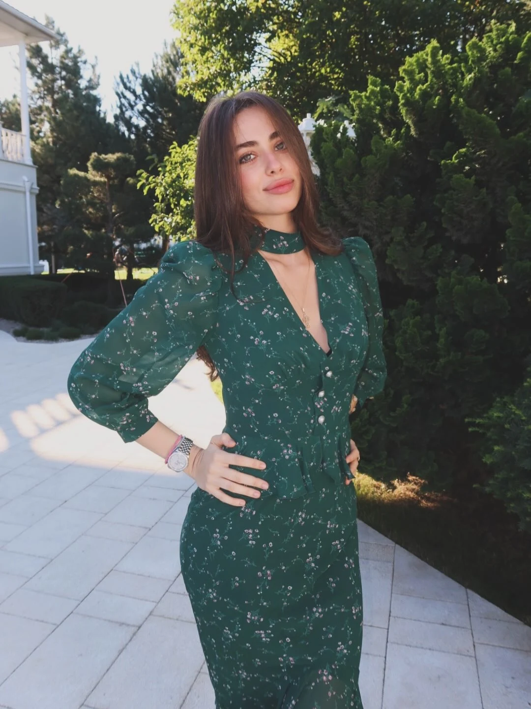 Dark green button-front floral dress with long gathered sleeves and a deep V neckline.