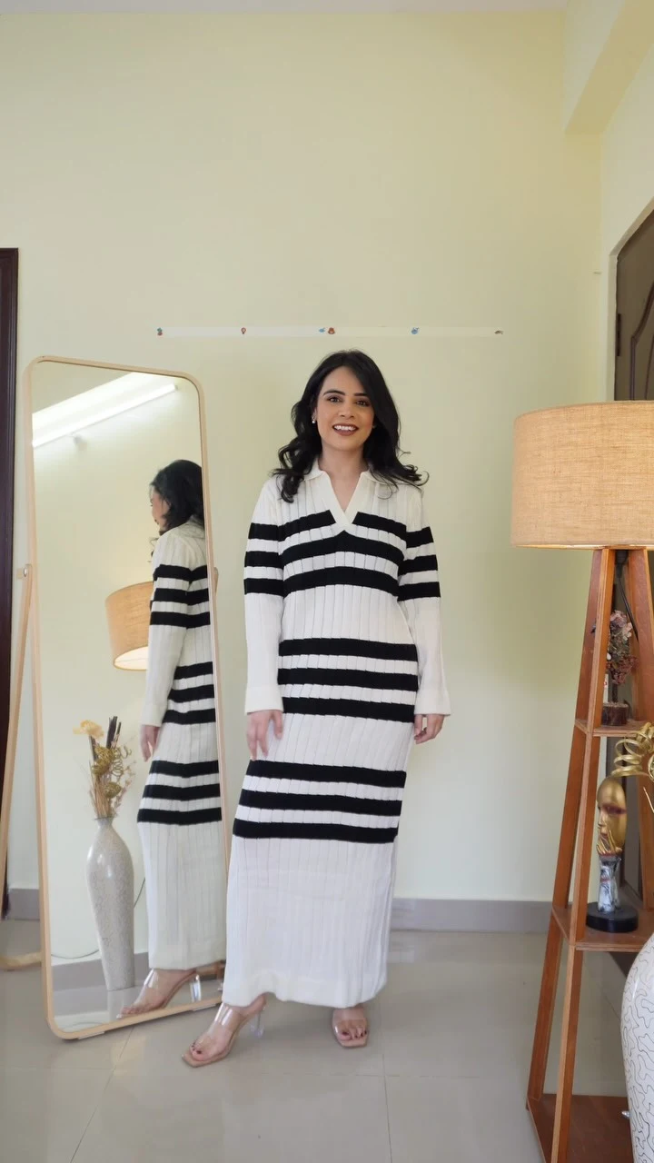 White ribbed knit maxi dress with bold black stripes and clear-strap heeled sandals.