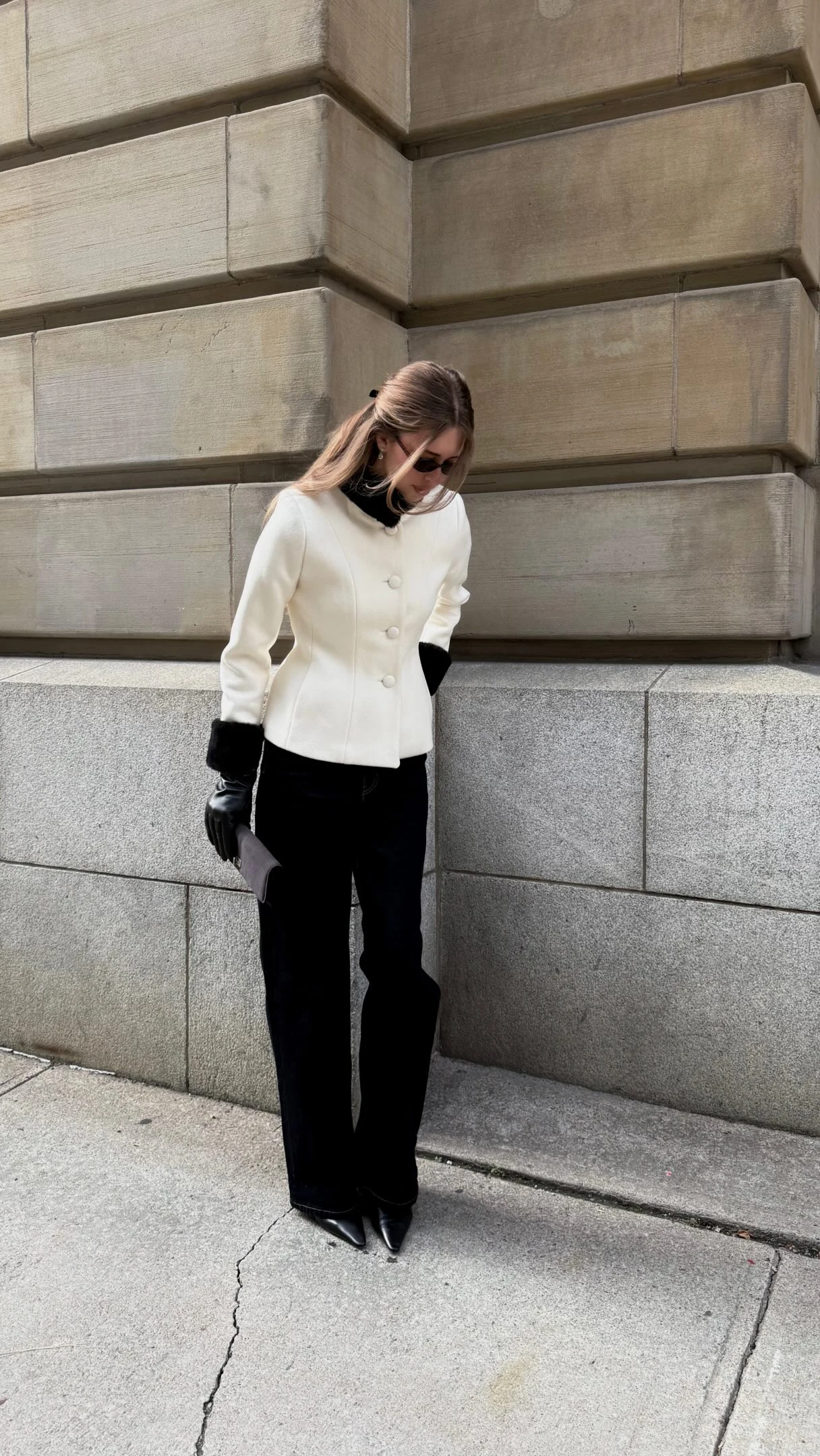Cream cropped coat with black fur collar and cuffs, black leather gloves, dark wide-leg trousers, black pointed-toe heels
